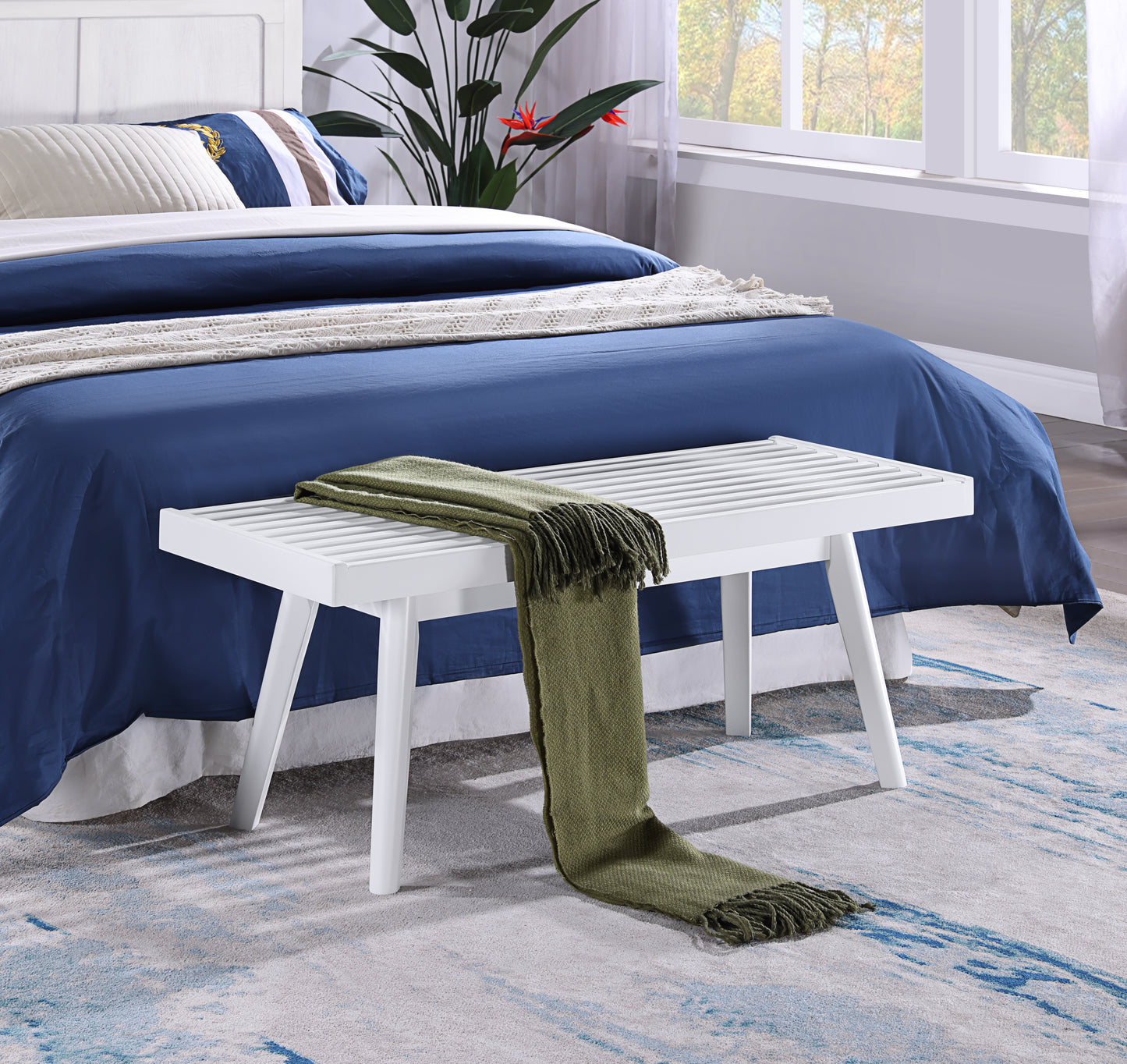 White slatted bench with green throw