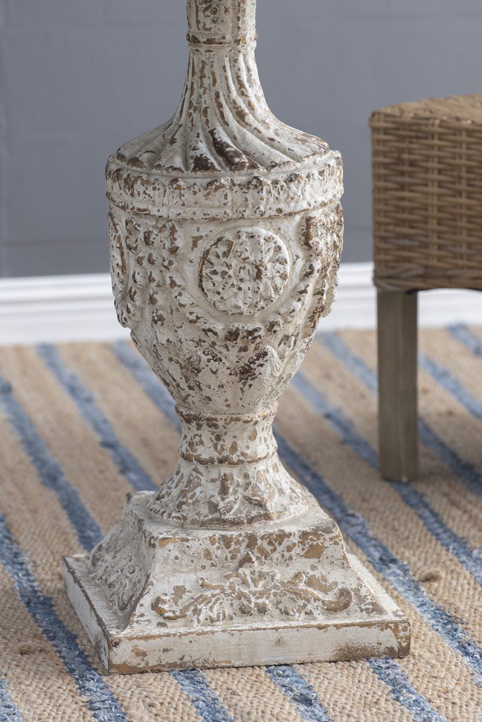 Distressed white antique urn with ornate carvings and gold accents a decorative accent piece