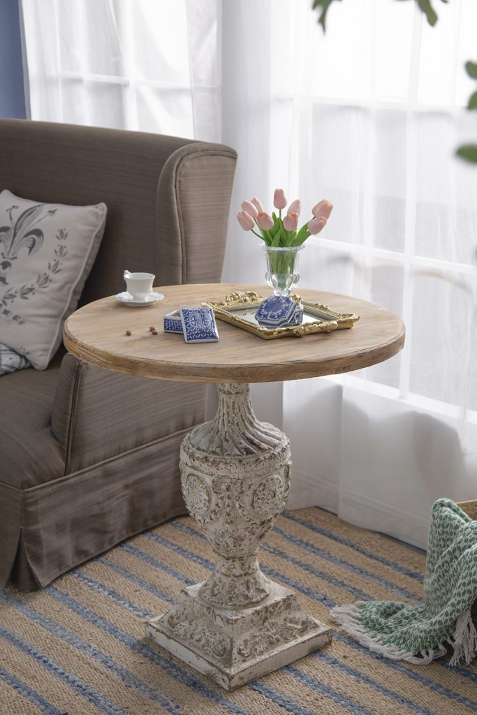 Distressed white pedestal accent table with a round wooden top