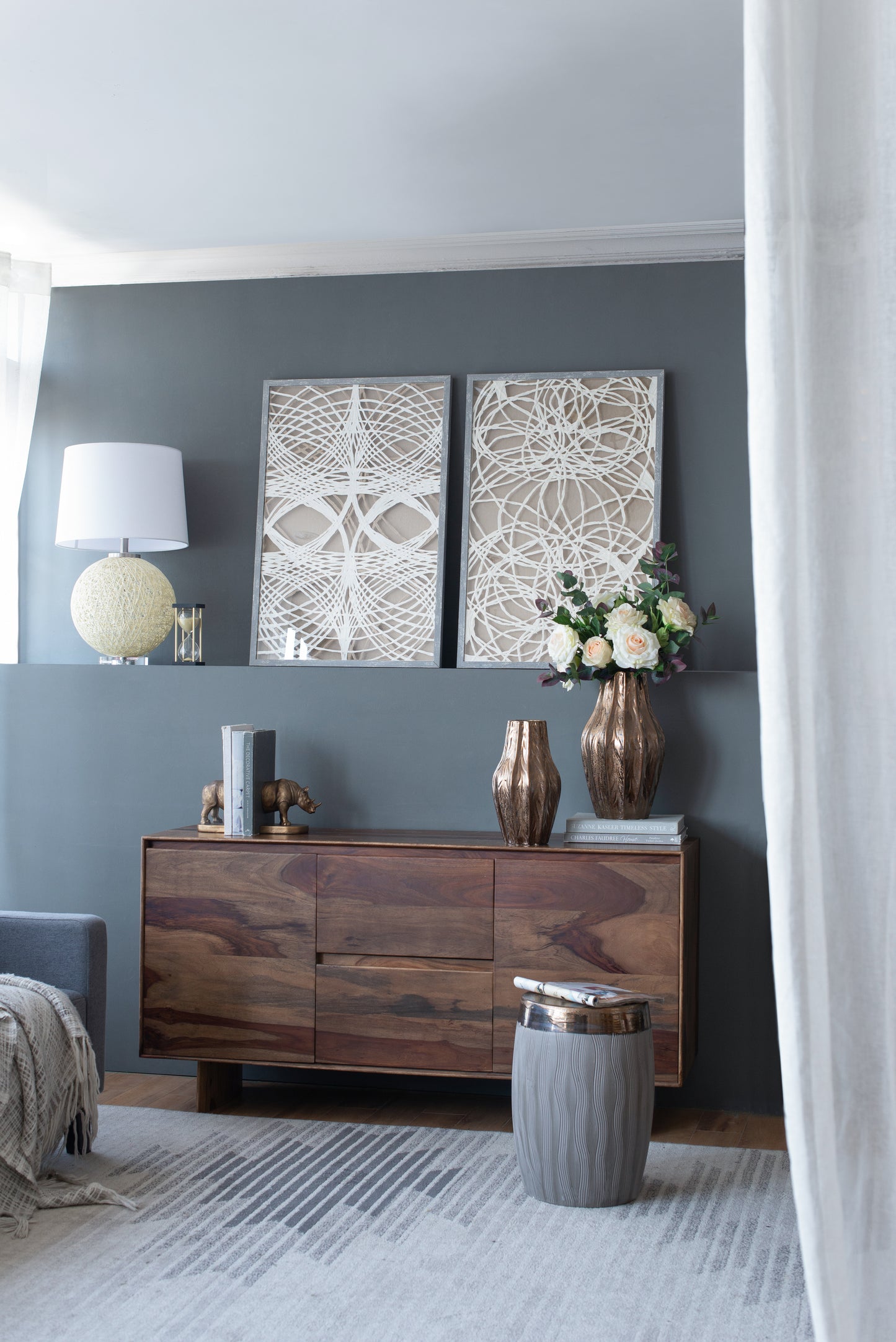 Warm wood credenza with brass elephant bookends and stack of books