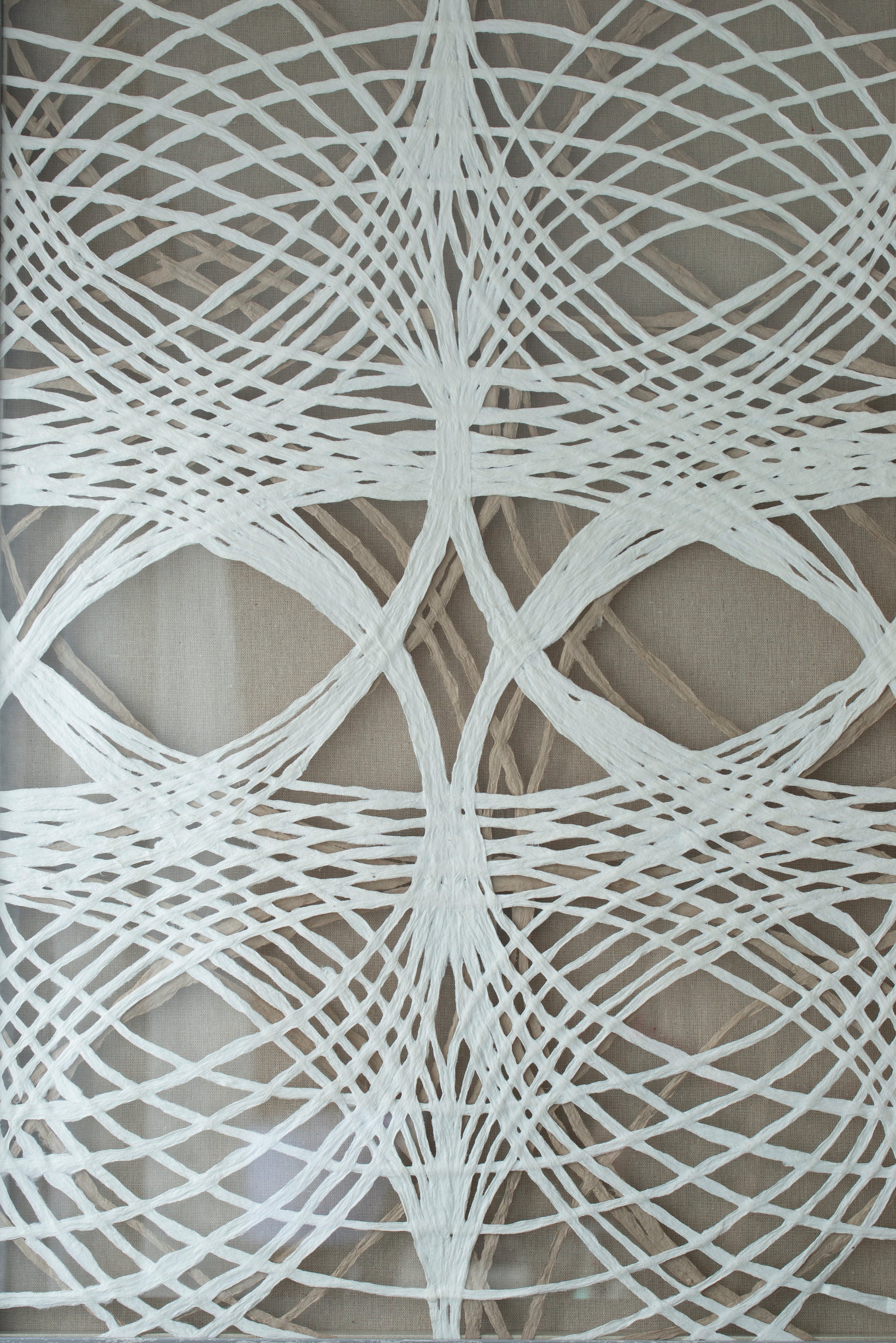 Intricate white thread art featuring a woven diamond pattern on a beige textured background perfect for wall decor