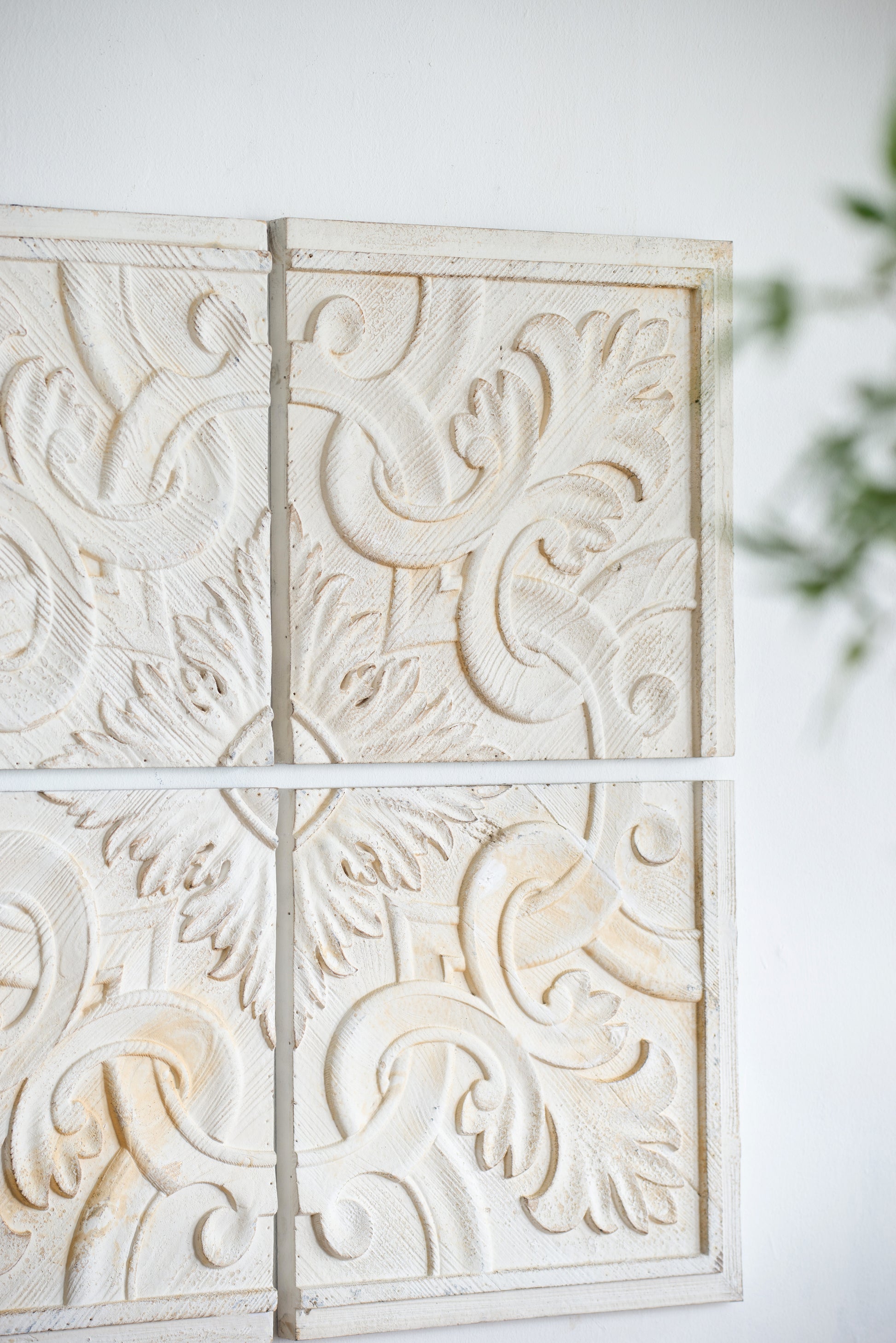 Closeup of antique white carved wooden wall panel with floral motif
