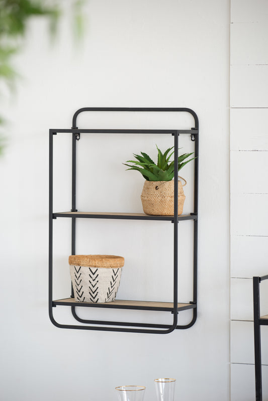 Black metal wall shelf with wooden shelves holding a potted plant