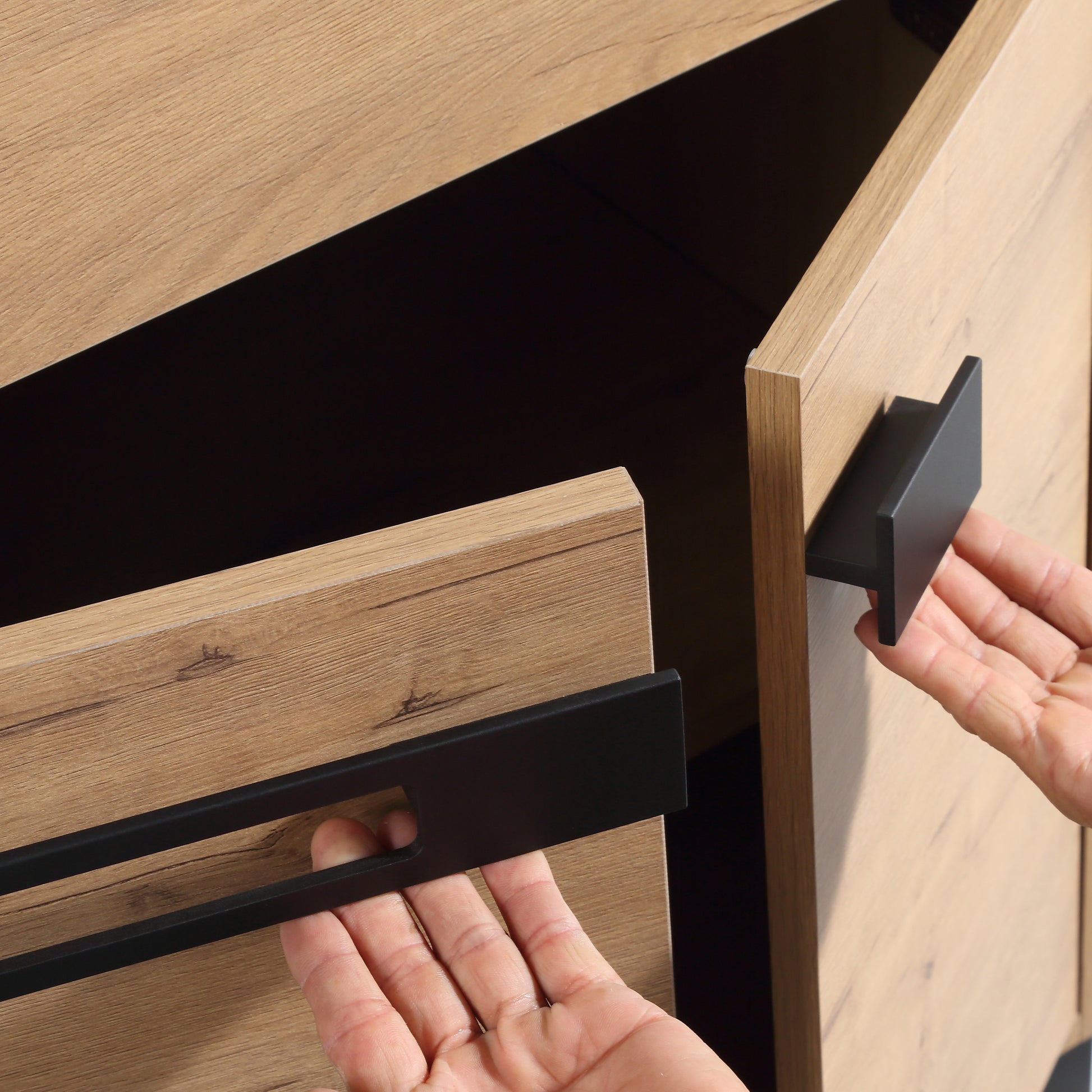 Modern oak veneer cabinet with black matte handles open drawer detail