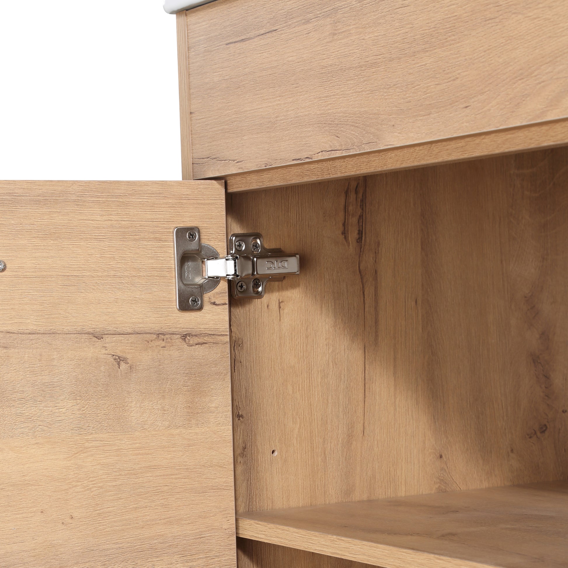 Closeup of a brushed metal cabinet hinge on a light oak wood door showcasing durable furniture hardware