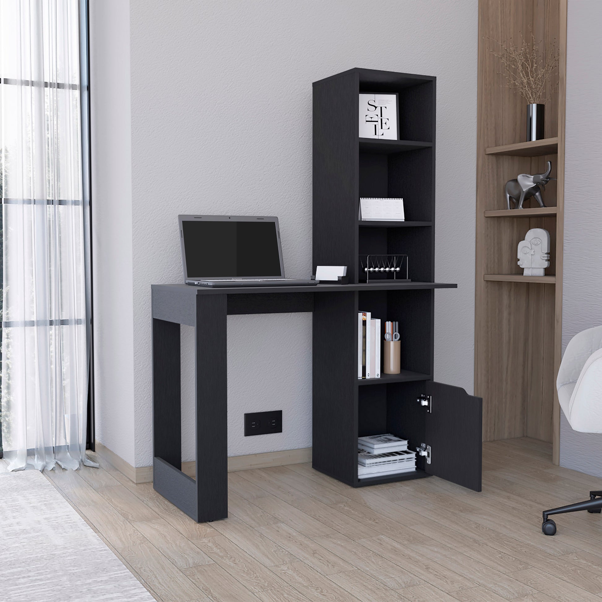 Dark gray modern computer desk with integrated shelving unit and laptop