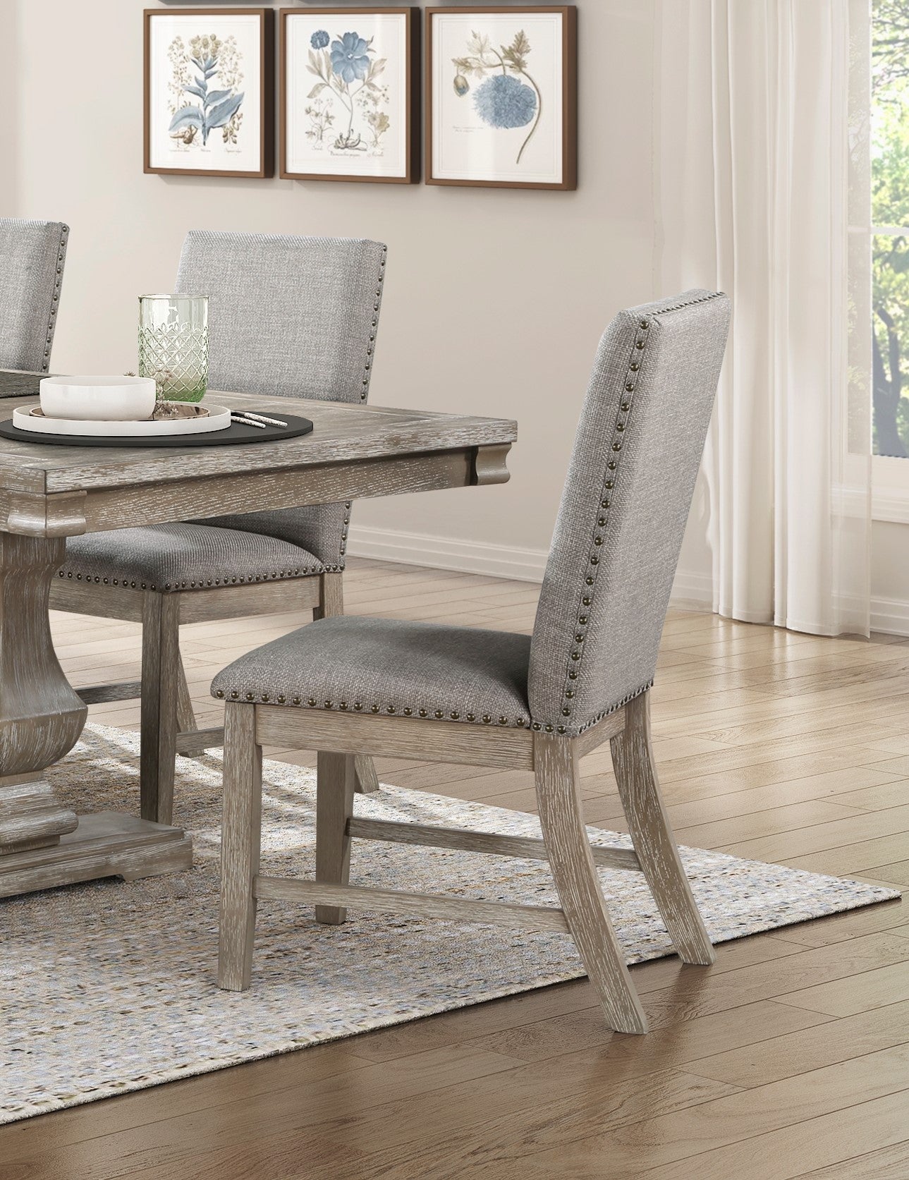 Gray upholstered dining chair with nailhead trim and distressed wood frame