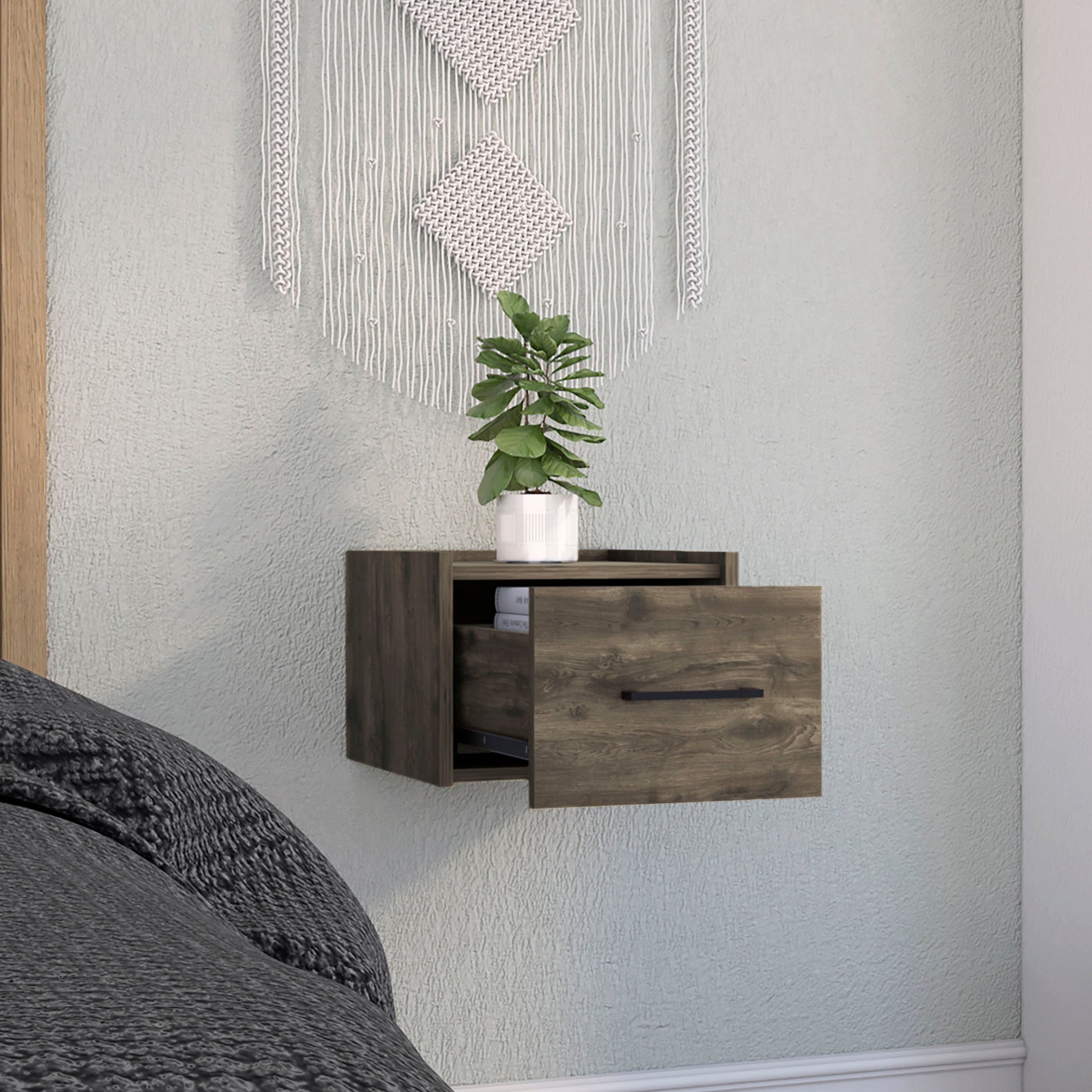 Dark wood modern floating nightstand with open drawer and black handle next to a bed