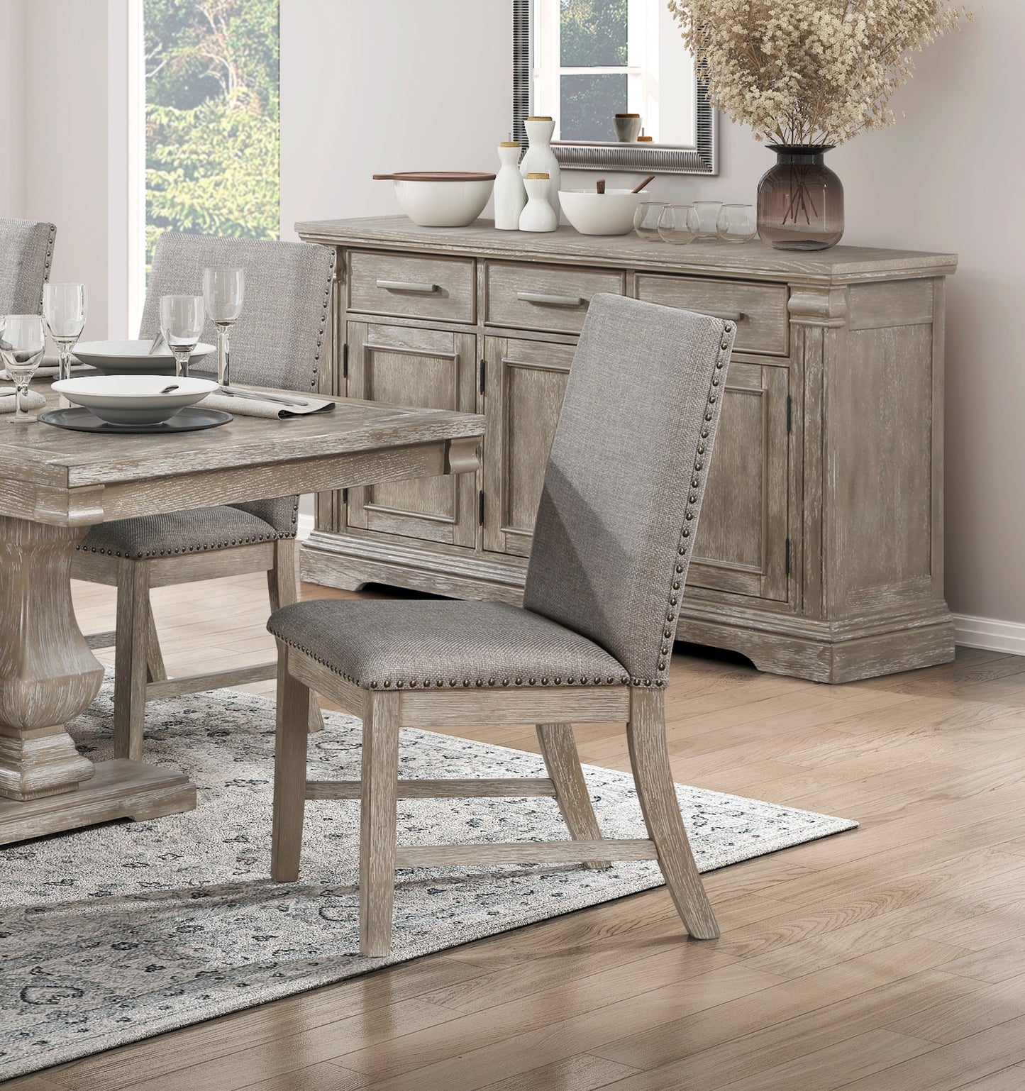 Gray upholstered dining chair with nailhead trim and distressed wood frame