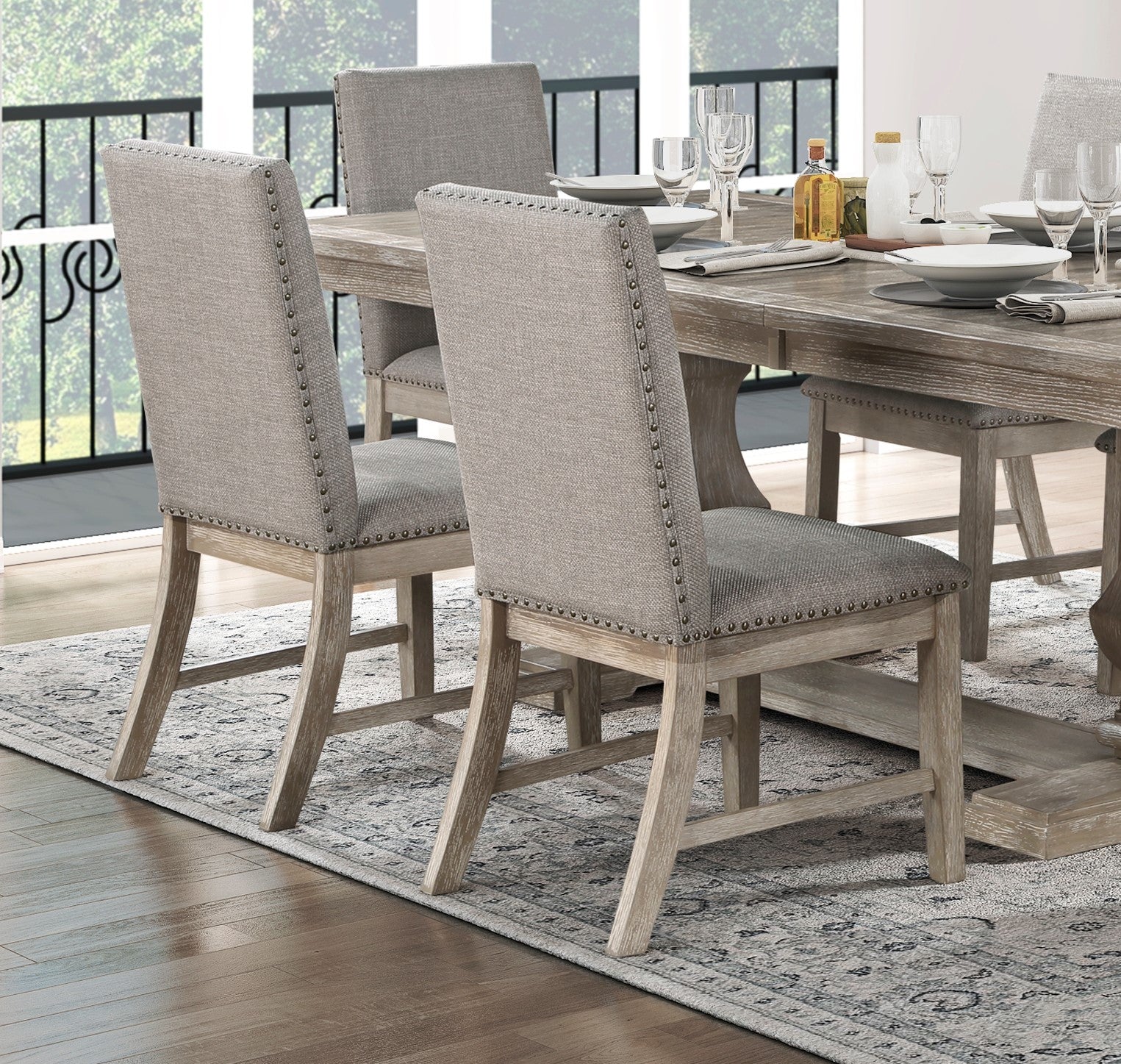 Tufted grey linen dining chair with nailhead trim and a weathered wood frame