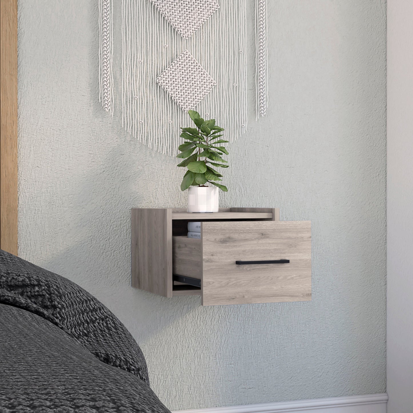 Floating wood nightstand with open drawer revealing books and black handle