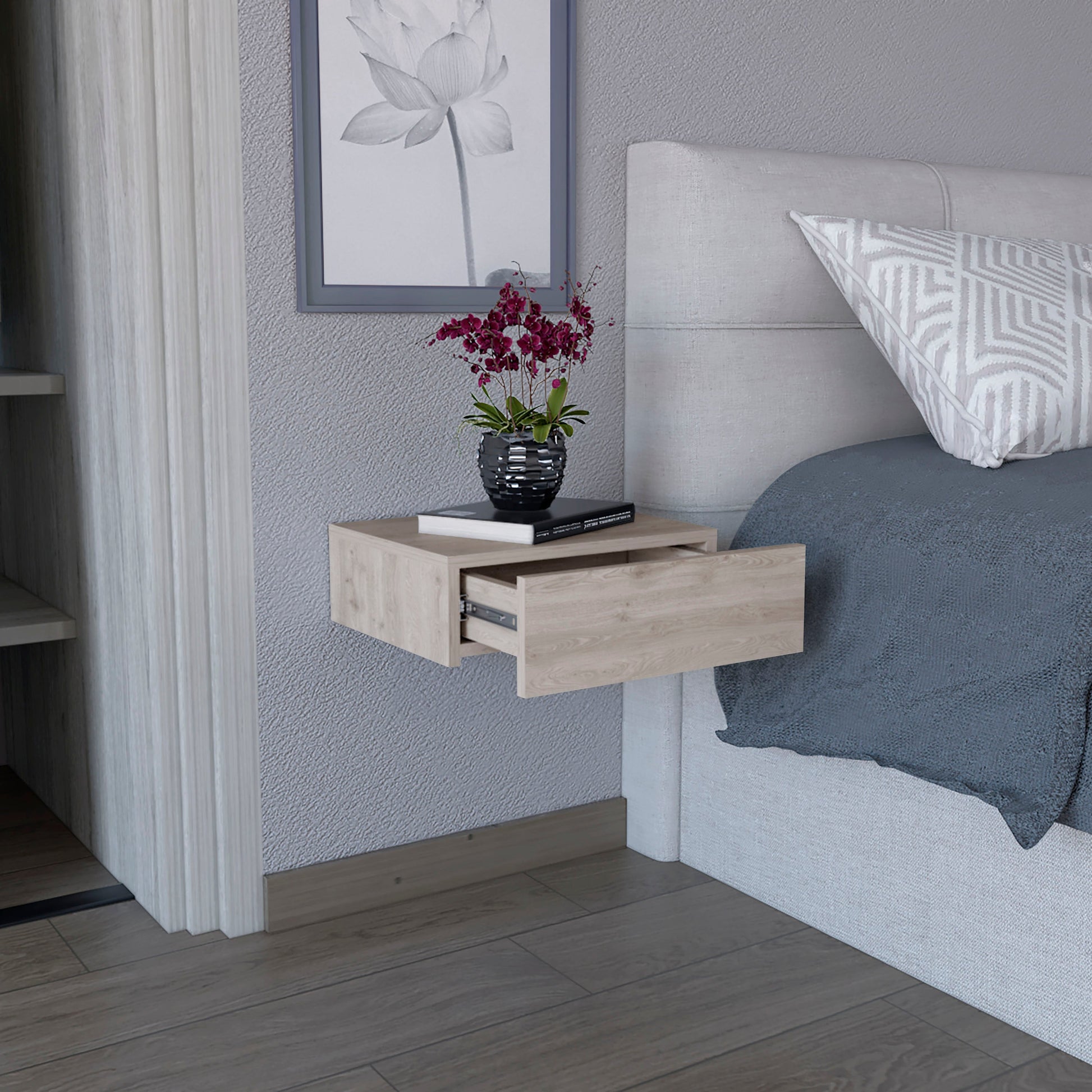 Light wood floating nightstand with an open drawer next to a bed