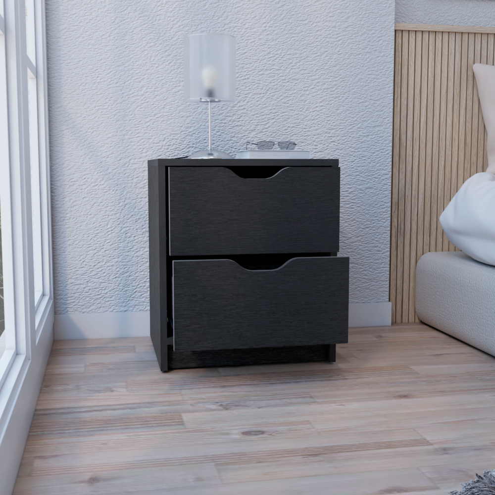 Black twodrawer nightstand with cutout handles beside a bed