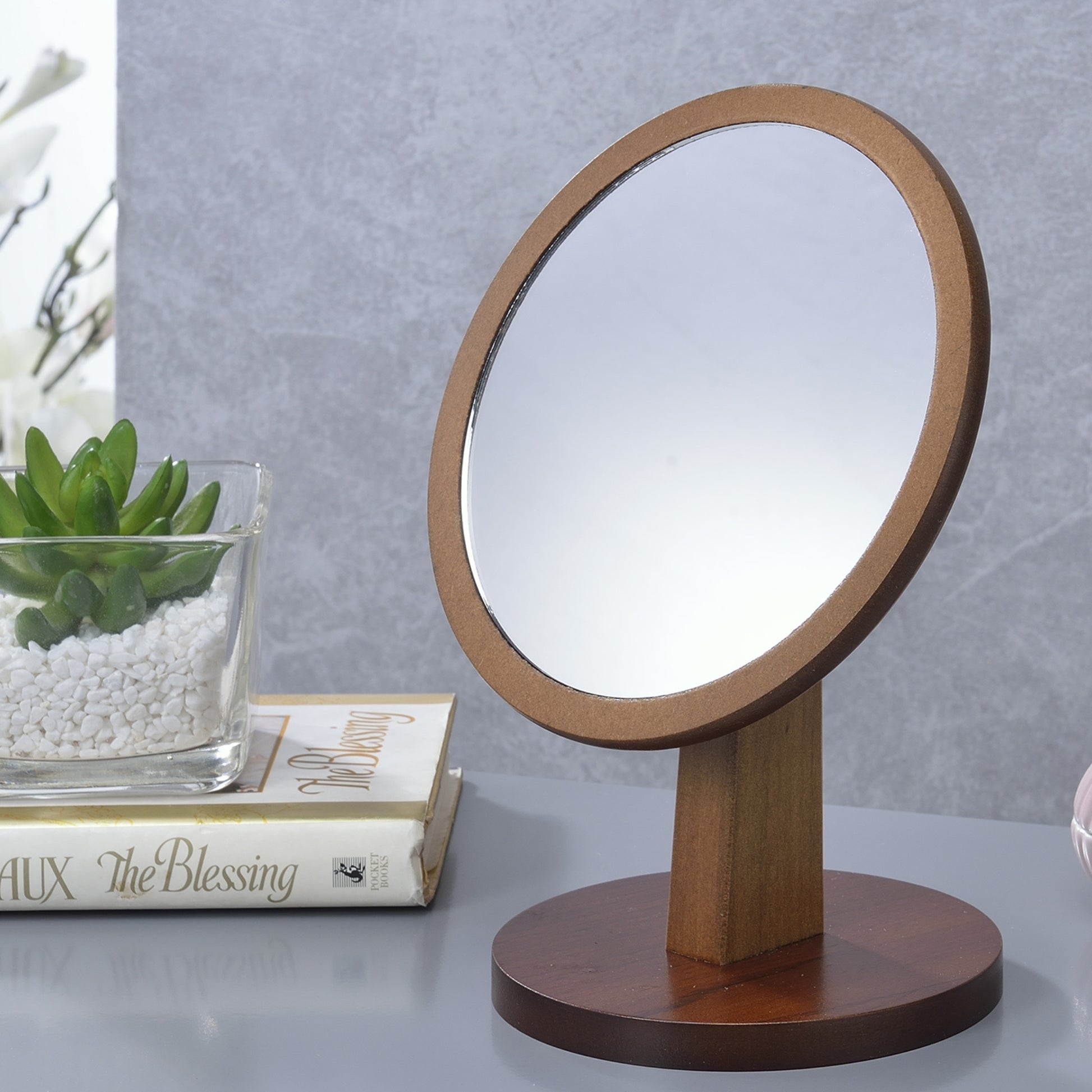 Wooden vanity mirror with round reflective surface and natural wood stand