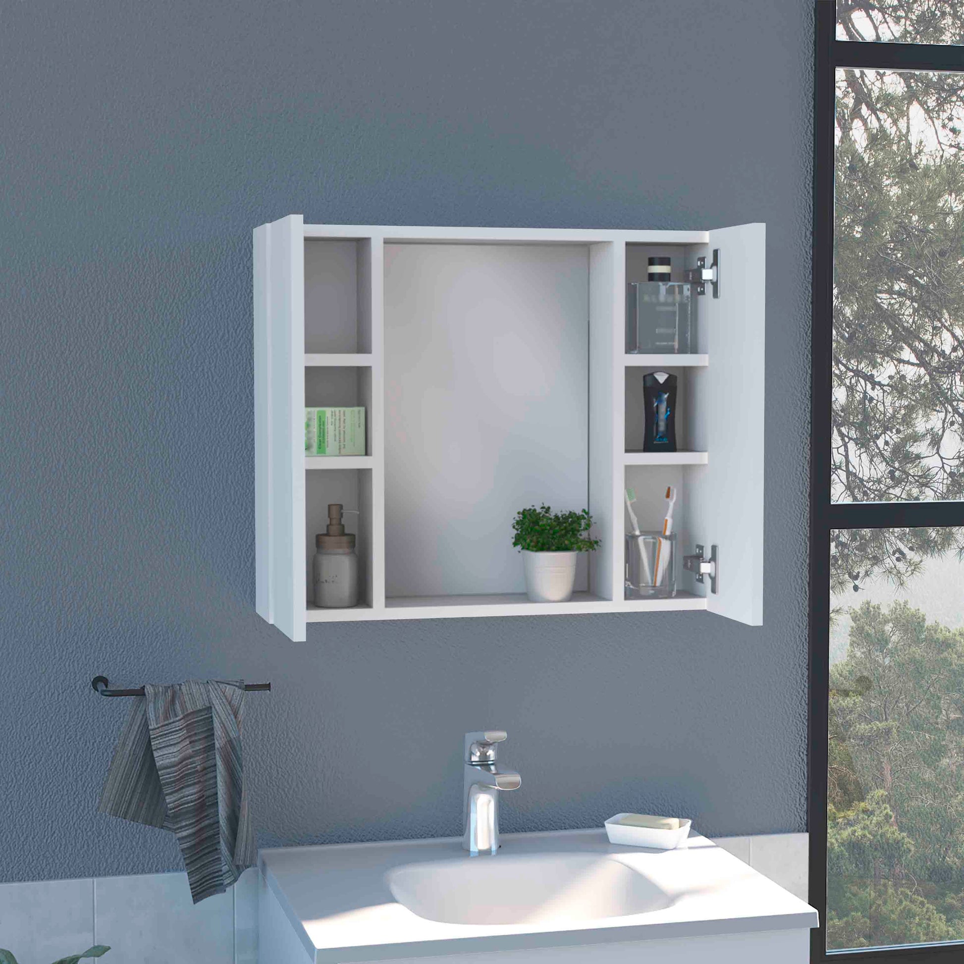 White mirrored medicine cabinet with open doors displaying toiletries and plant