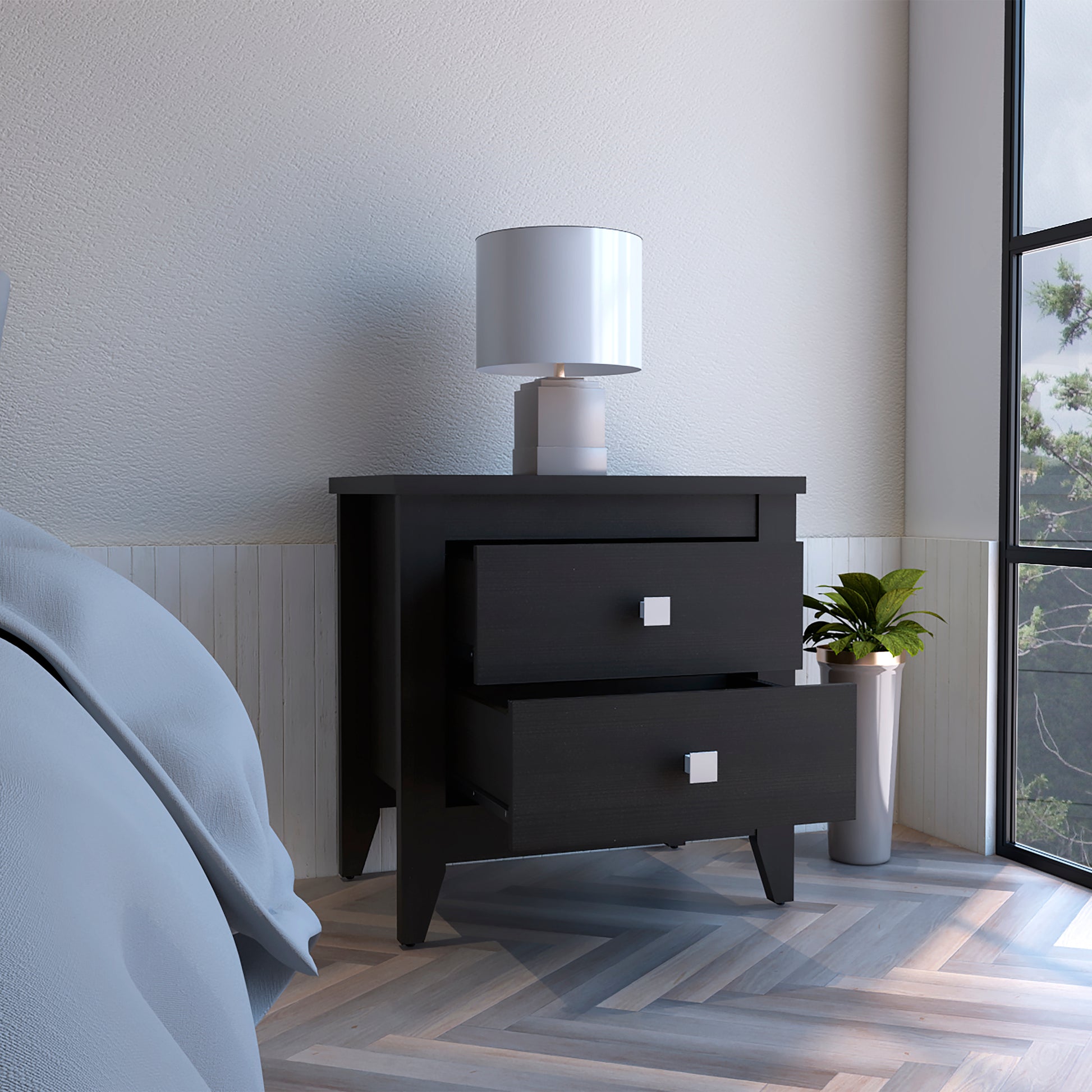 Modern black twodrawer nightstand with silver pulls and a white drum shade lamp