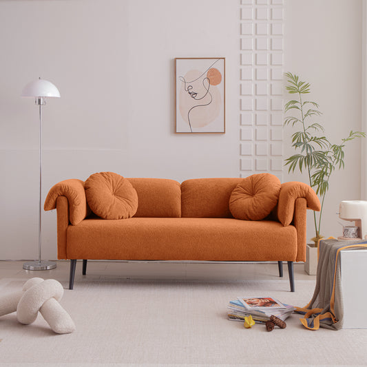 Orange boucle sofa with two round throw pillows and black legs