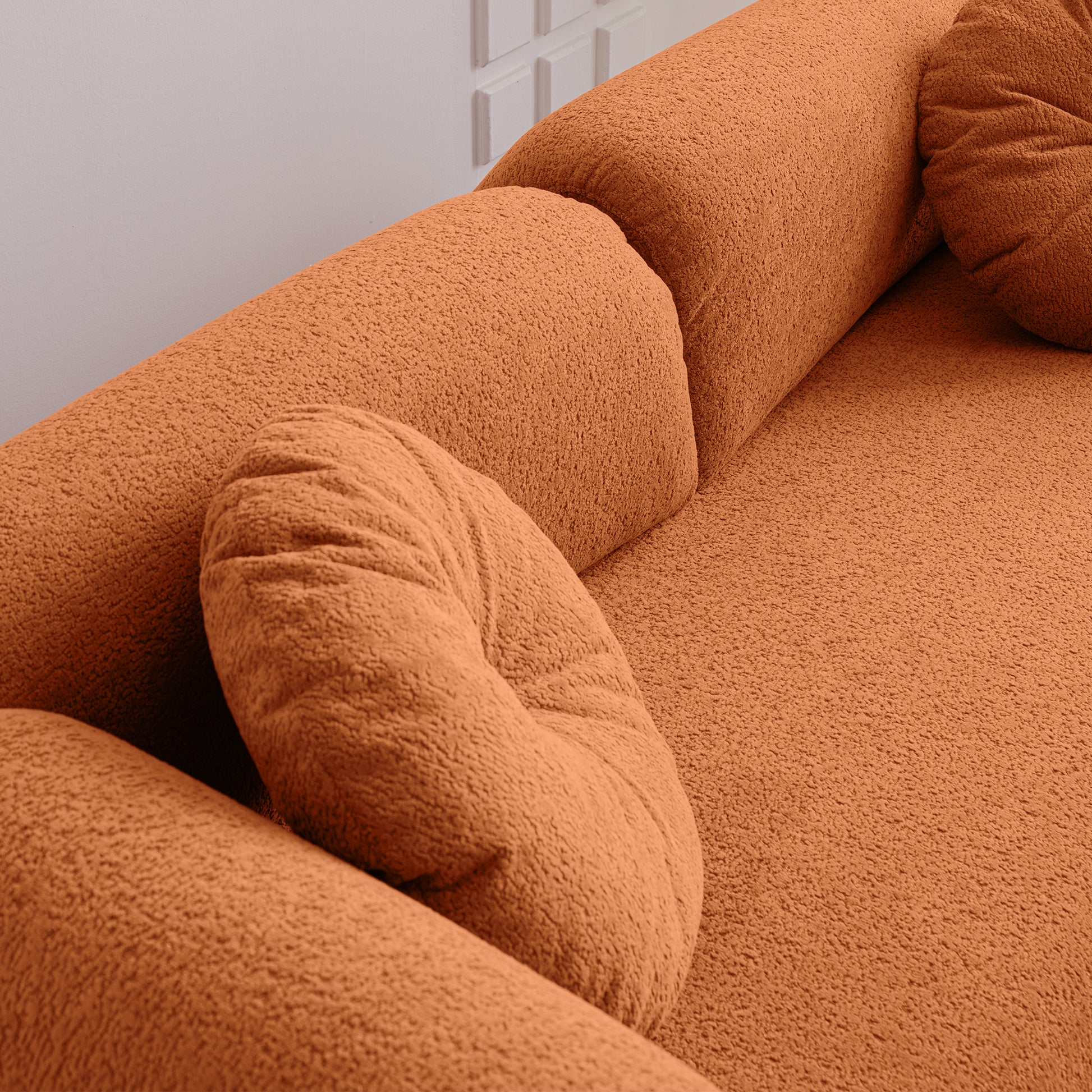 Plush orange boucle fabric sofa with textured cushions for a modern living room  characters