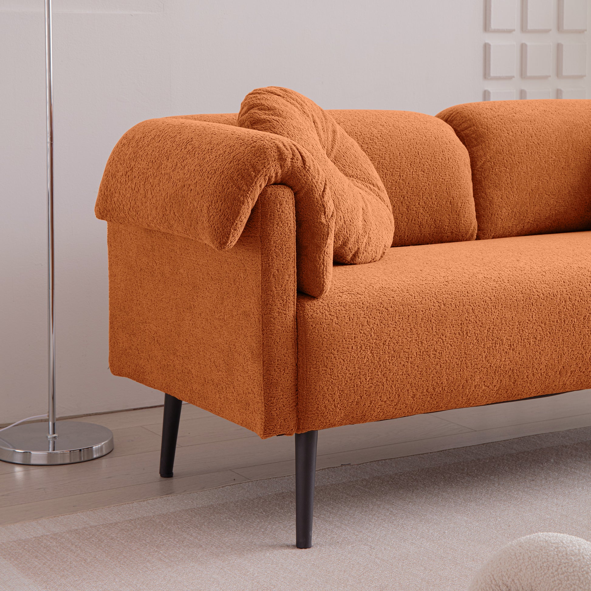 Orange textured boucl sofa with deep seating and plush throw pillows