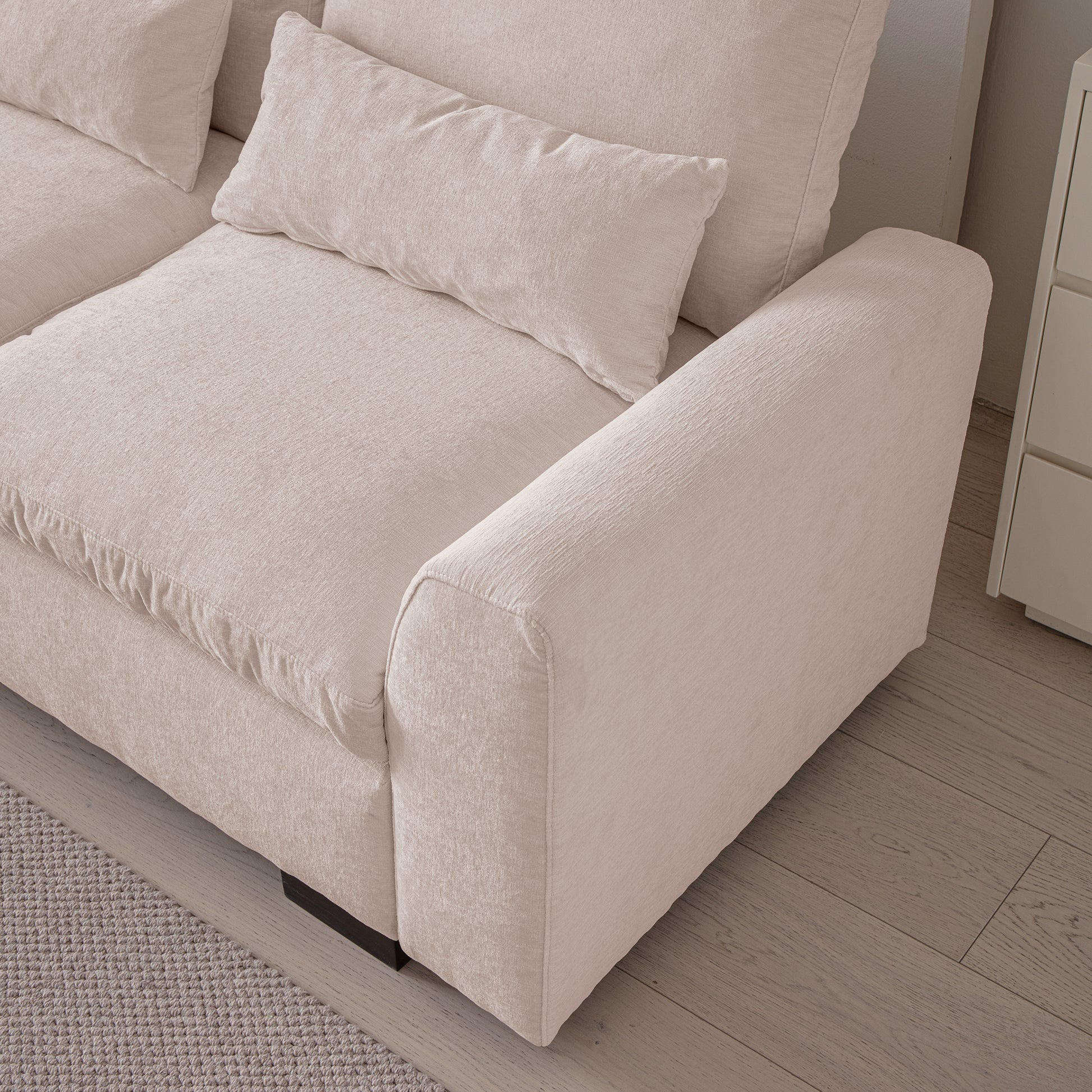 Plush beige linen sofa with thick comfortable cushions and a bolster pillow