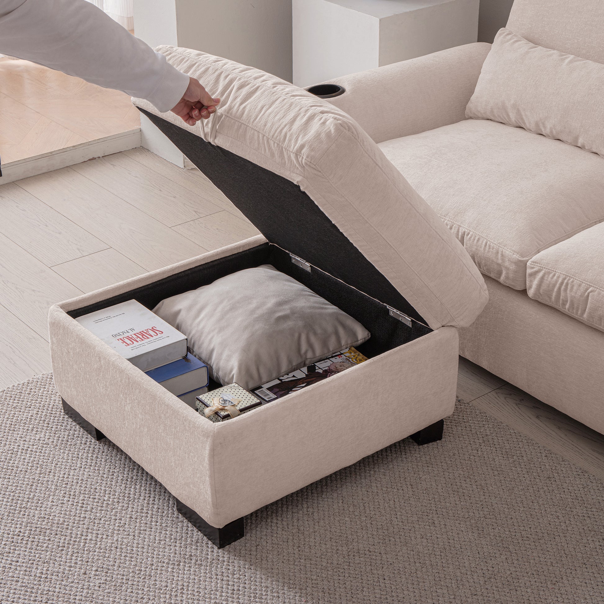 Cream upholstered ottoman with lifttop revealing storage for books and pillows