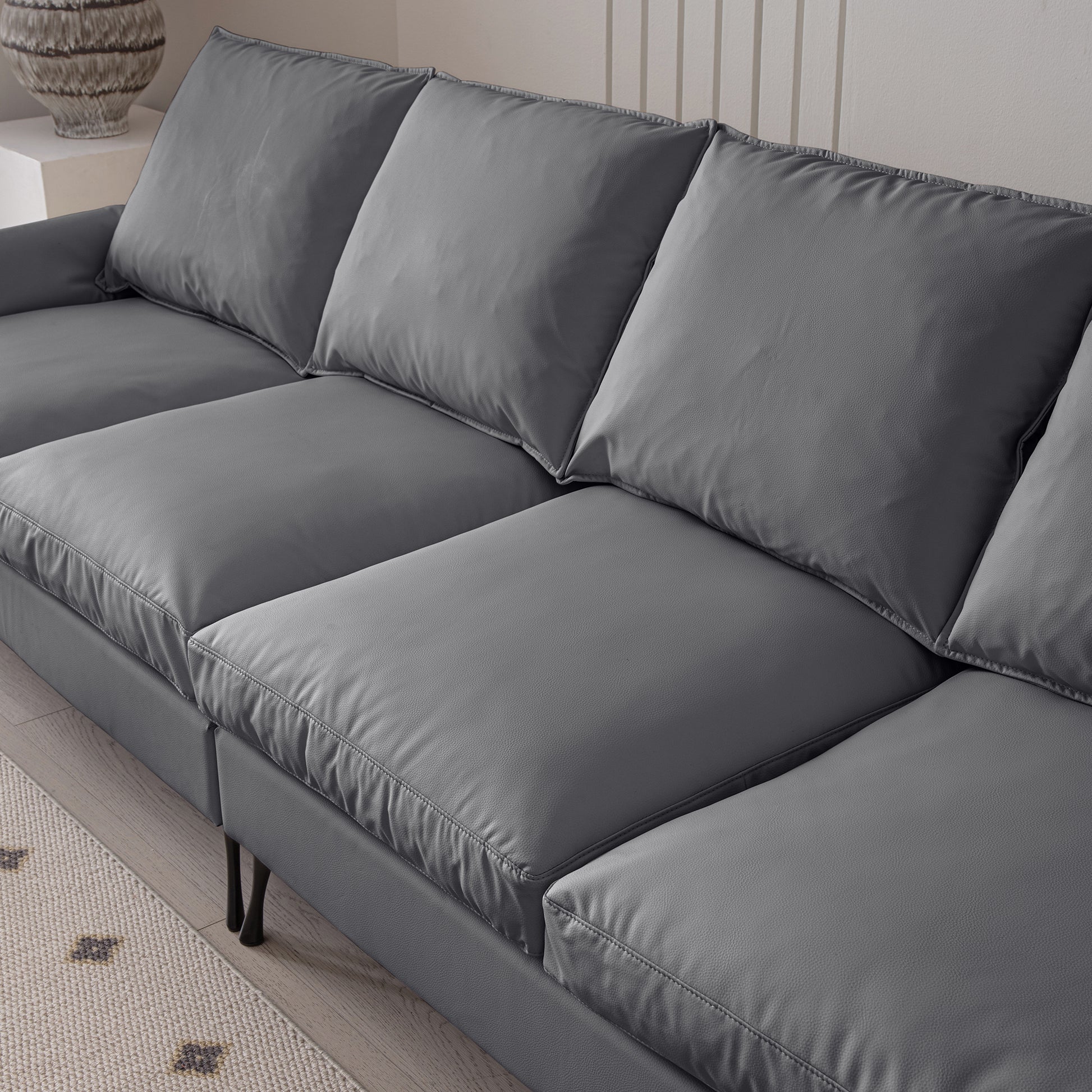 Modern charcoal grey leather sectional sofa with deep seating and plush cushions