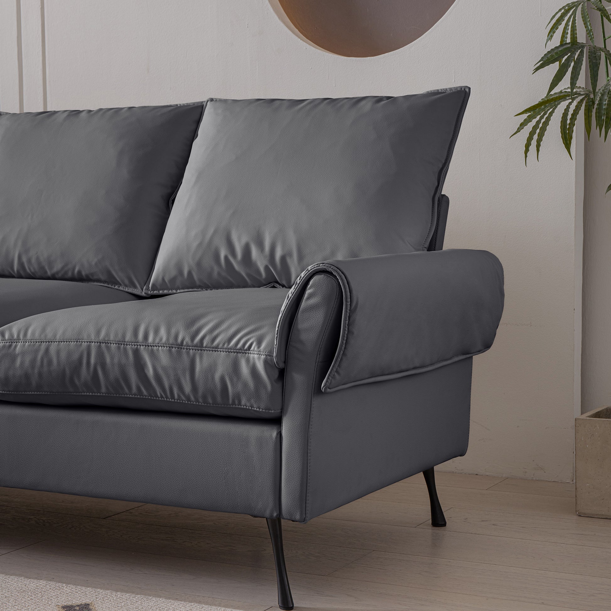 Dark grey faux leather sofa with plush cushions and elegant rolled armrests