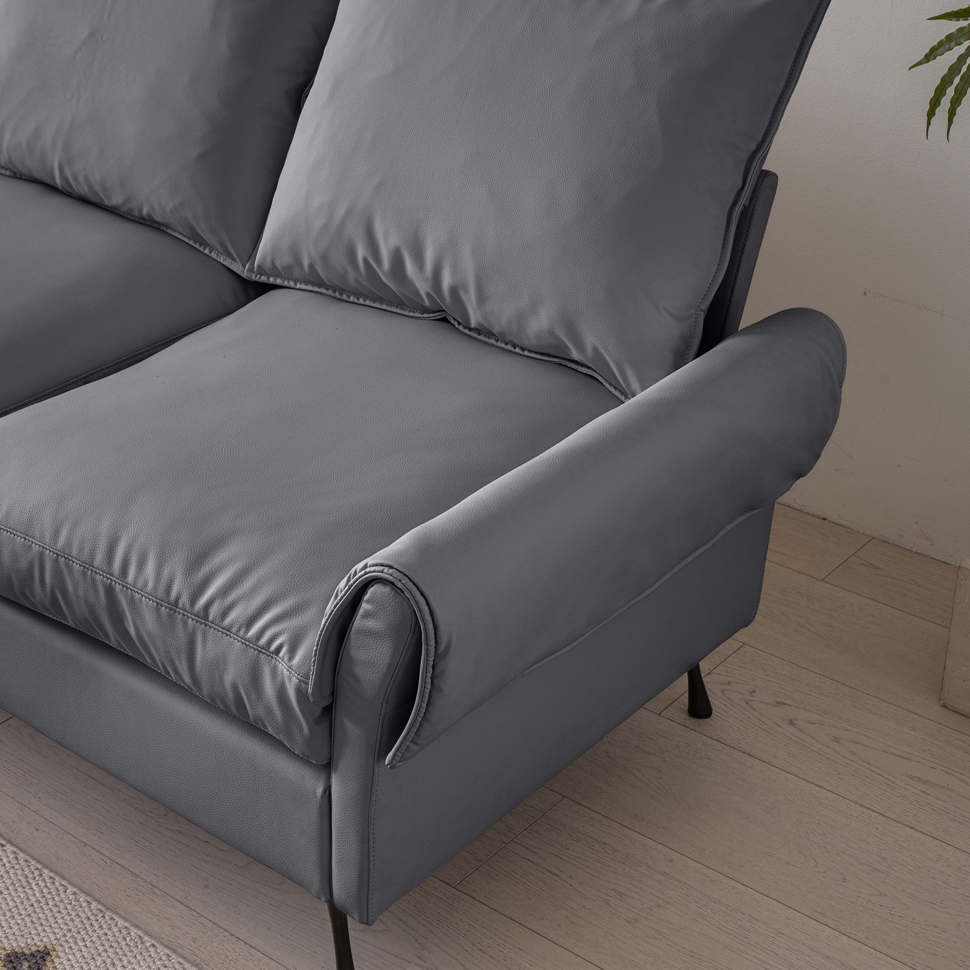 Dark gray faux leather sectional sofa with plush cushions and curved arms modern design