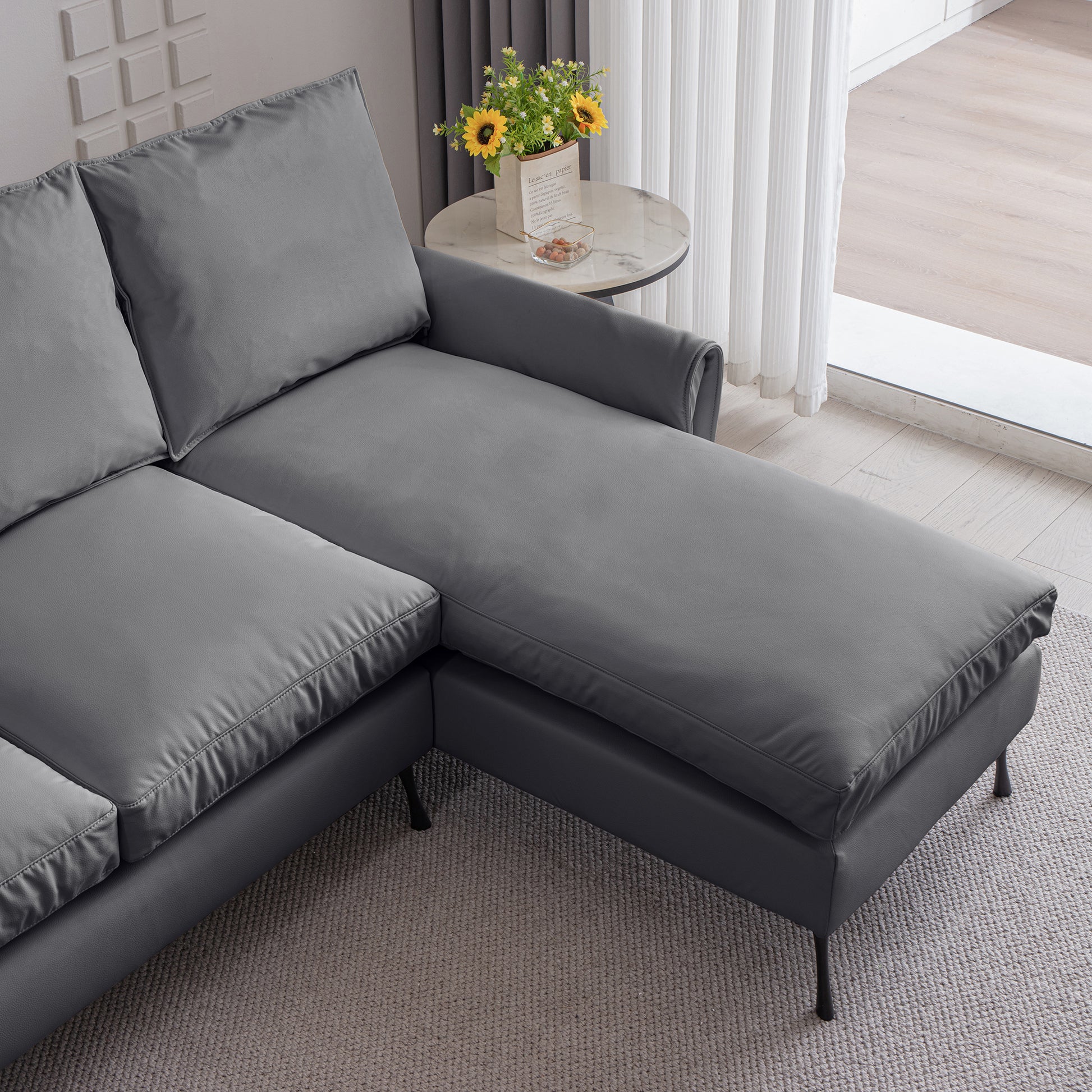 Dark grey faux leather sectional sofa with chaise lounge perfect for modern living rooms