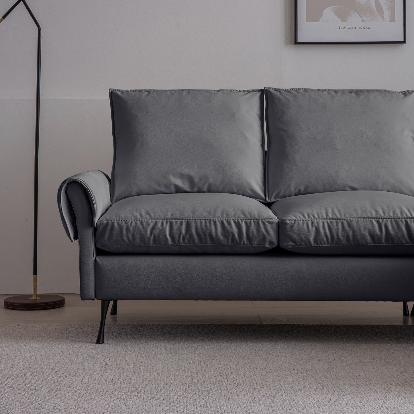 Dark gray faux leather sofa with plush cushions and a sleek modern design