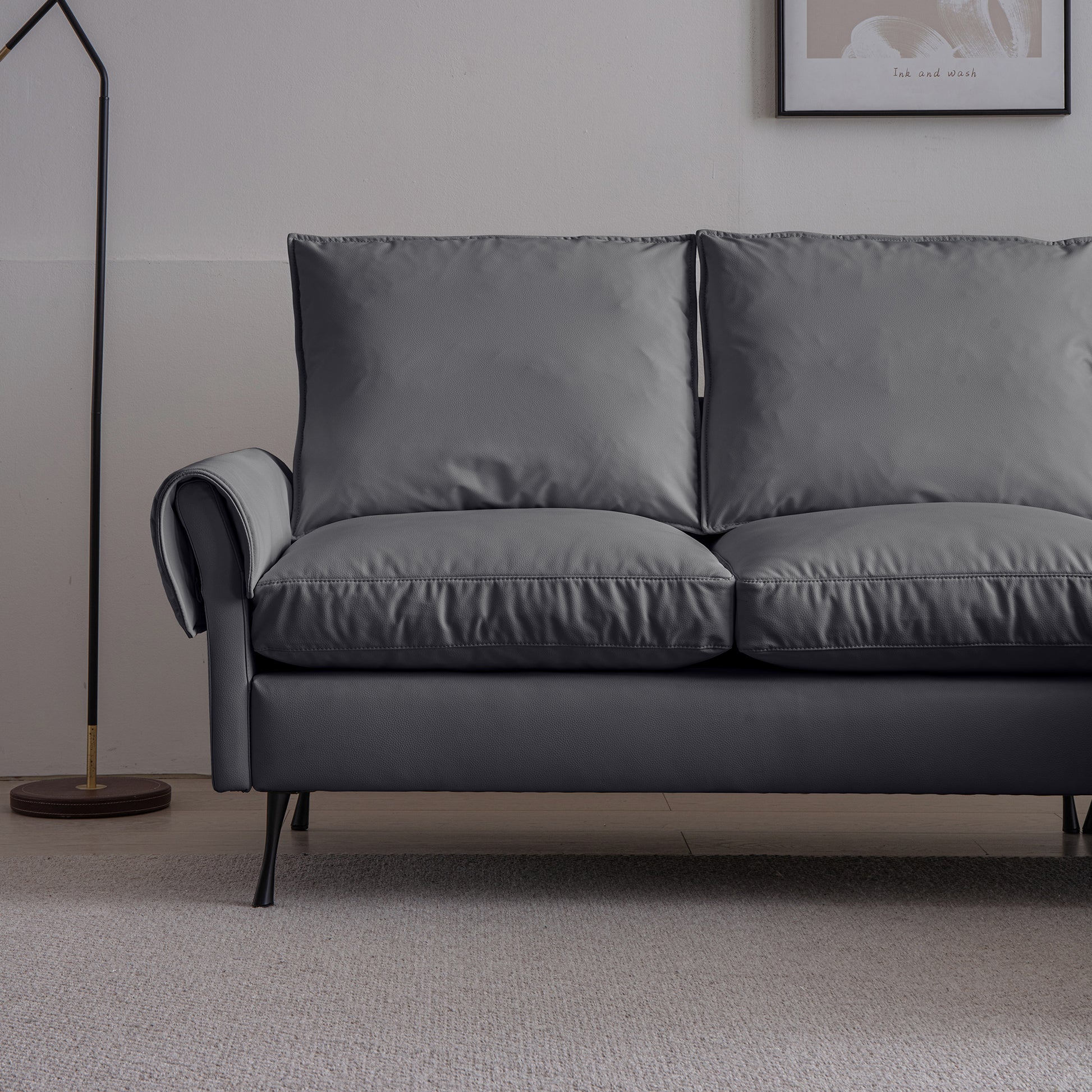 Dark gray faux leather sofa with plush cushions and a sleek modern design