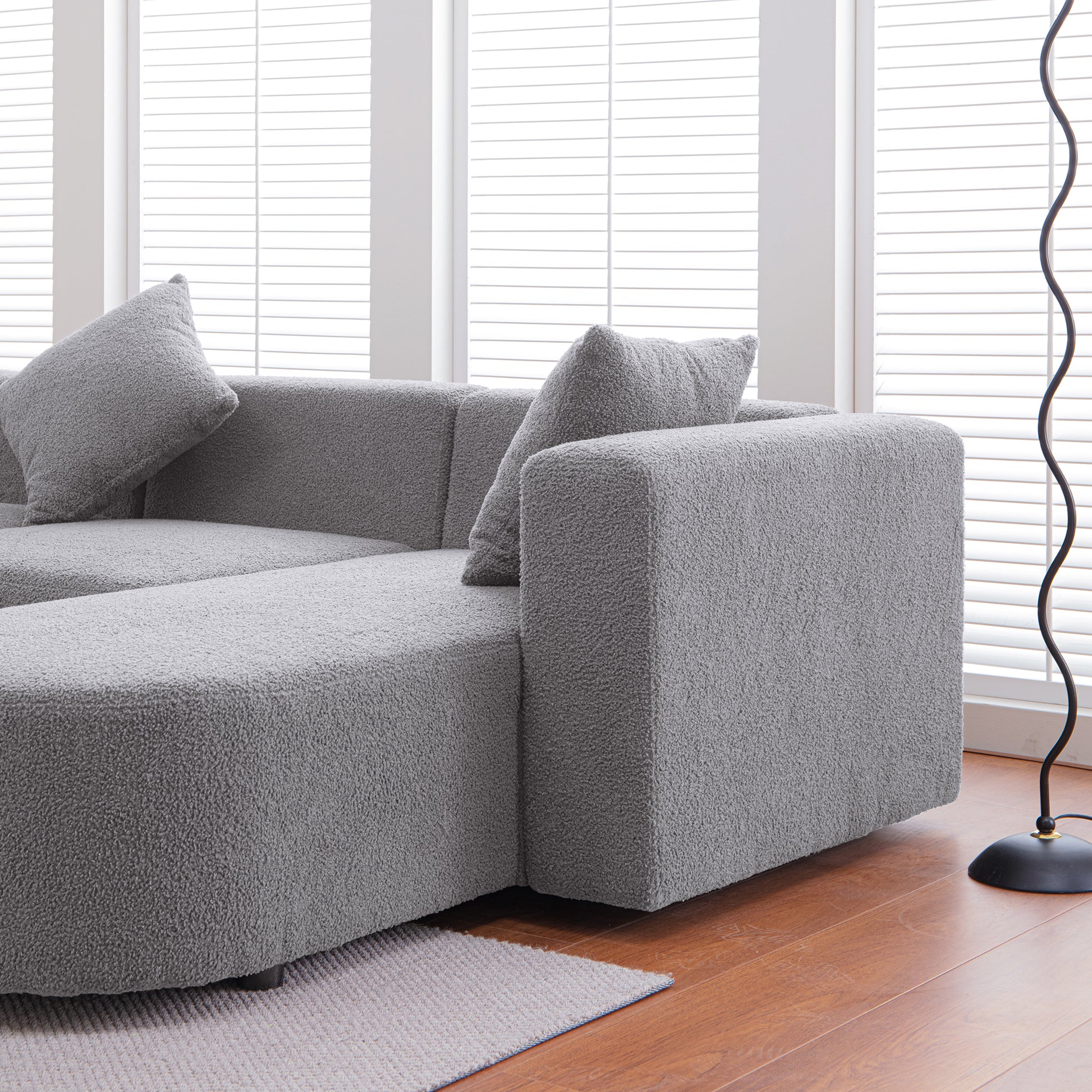 Plush gray sectional sofa with textured fabric and matching throw pillows perfect for modern living rooms