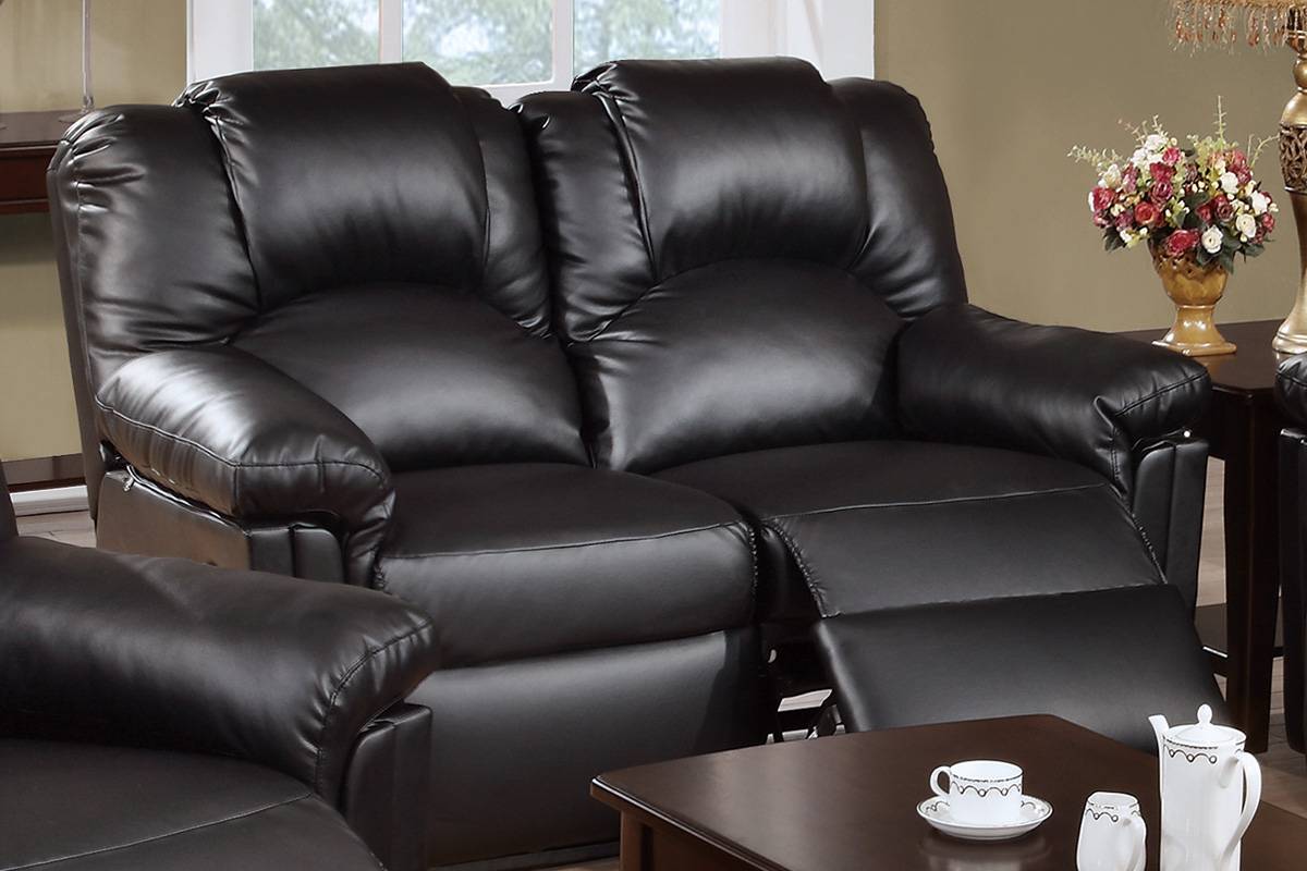 Plush black leather reclining loveseat with padded arms and headrests for ultimate comfort