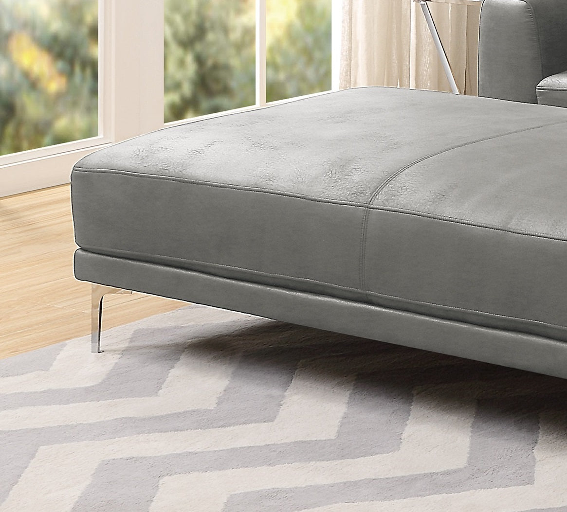 Closeup of grey leather chaise lounge cushion with stitched detailing and chrome legs