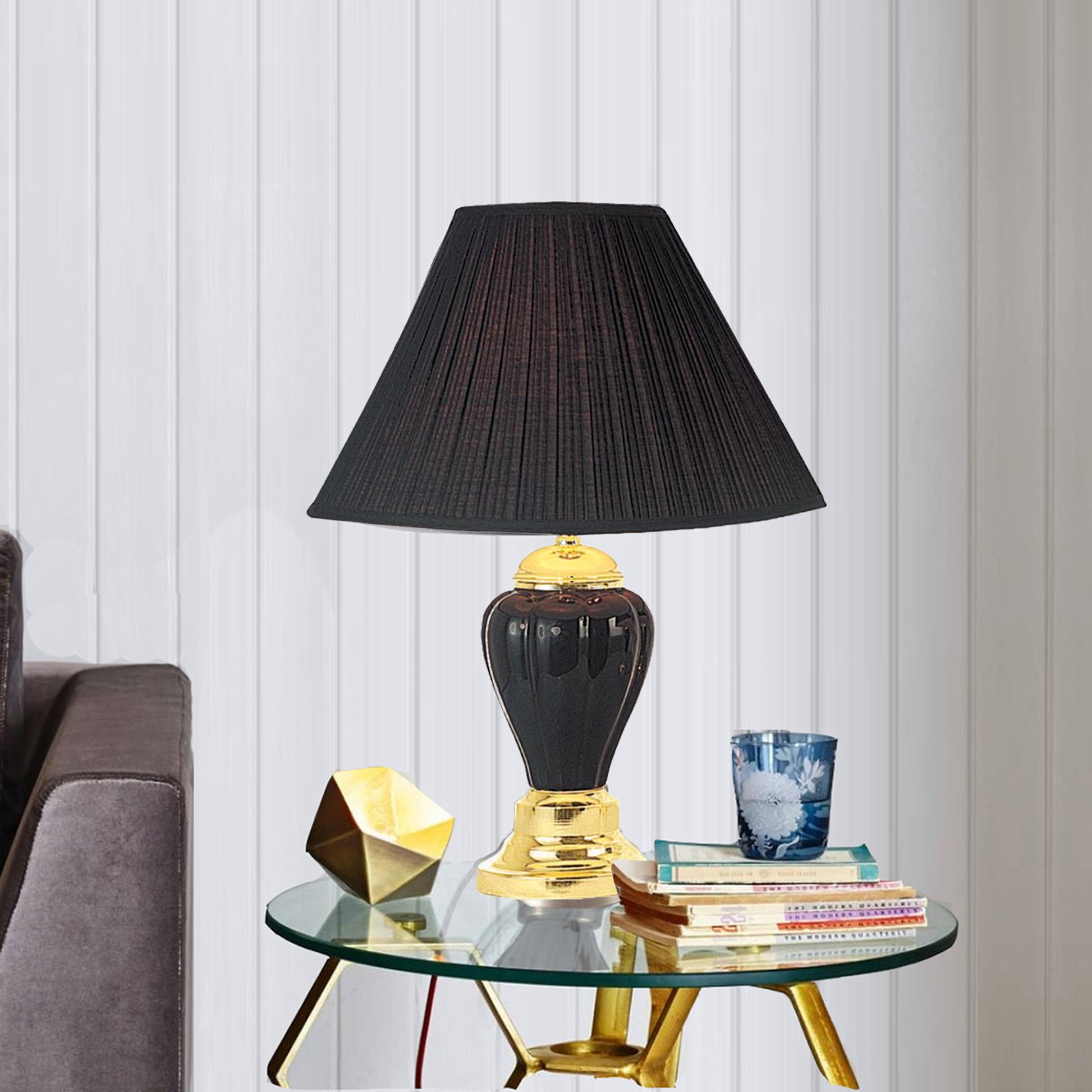Elegant black pleated shade table lamp with a dark ceramic base and gold accents