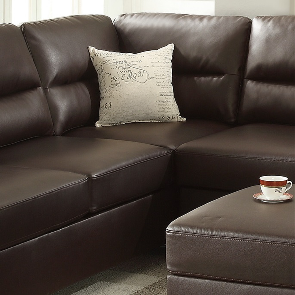 Rich brown leather sectional sofa with decorative pillow and ottoman