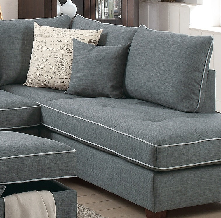 Deep gray sectional sofa with white piping and decorative throw pillows