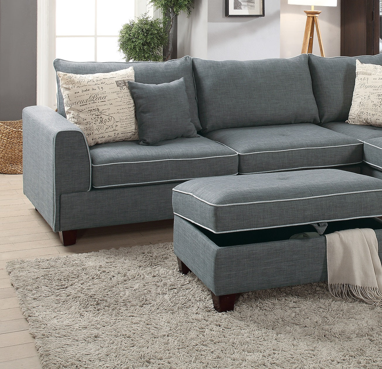 Gray sectional sofa with contrasting white piping and accent pillows ideal for living rooms