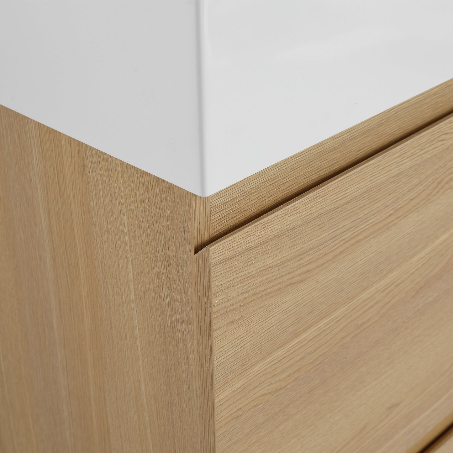 Closeup of a modern oak wood vanity with a white composite sink top