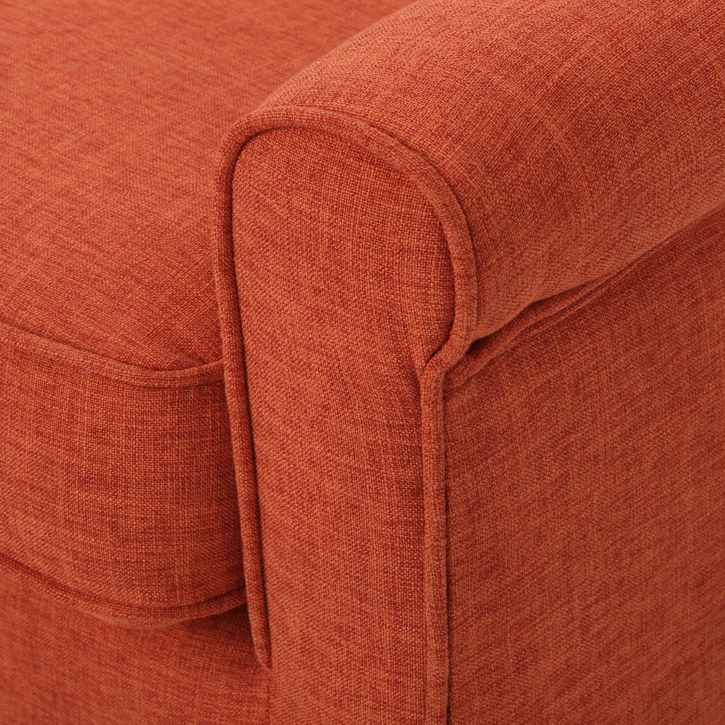 Closeup of textured terracotta woven fabric on a sofa armrest