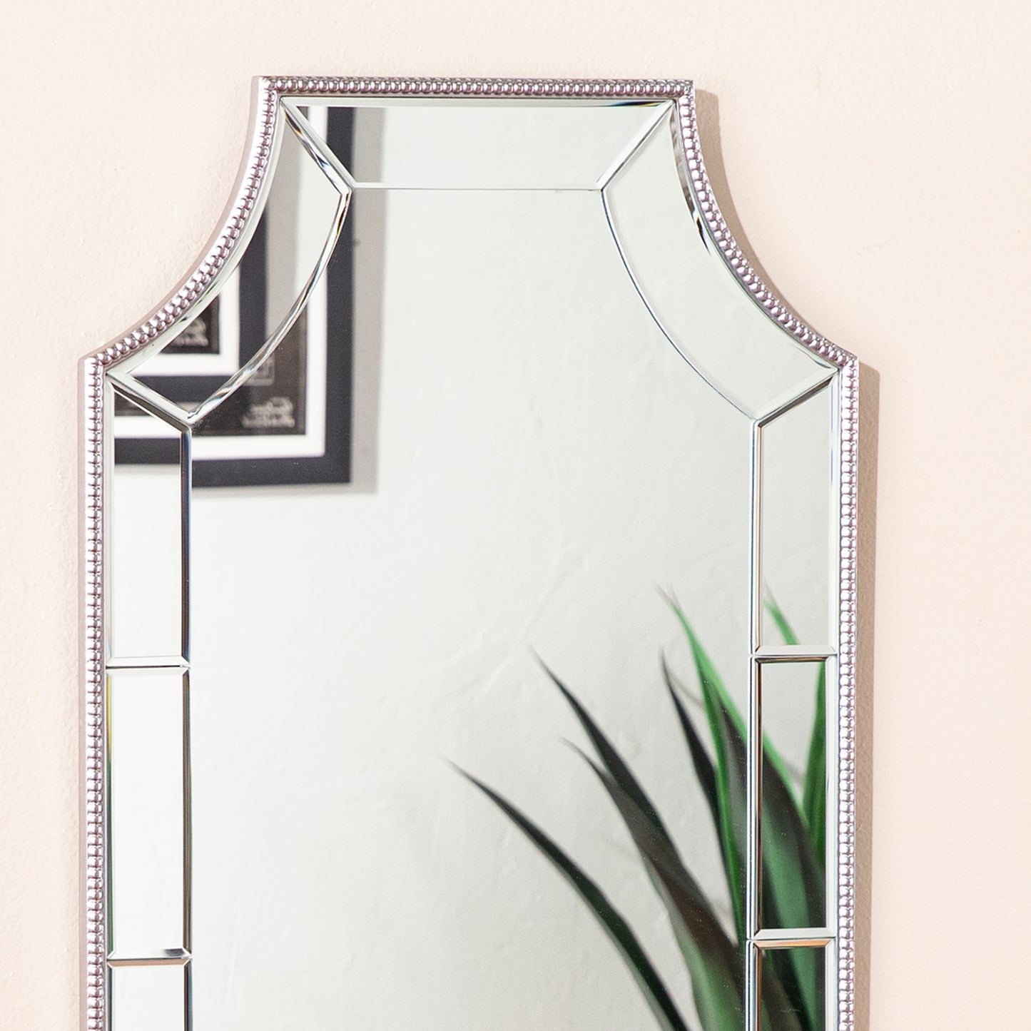 Ornate silverframed wall mirror with beveled glass panels for a touch of elegance