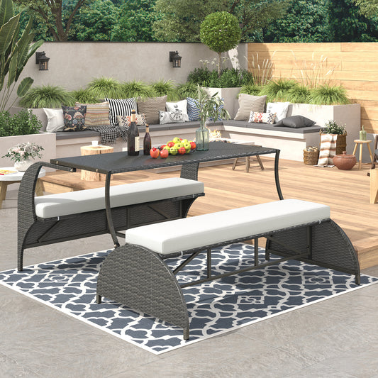 Gray wicker outdoor dining set with white cushions and a black glasstop table