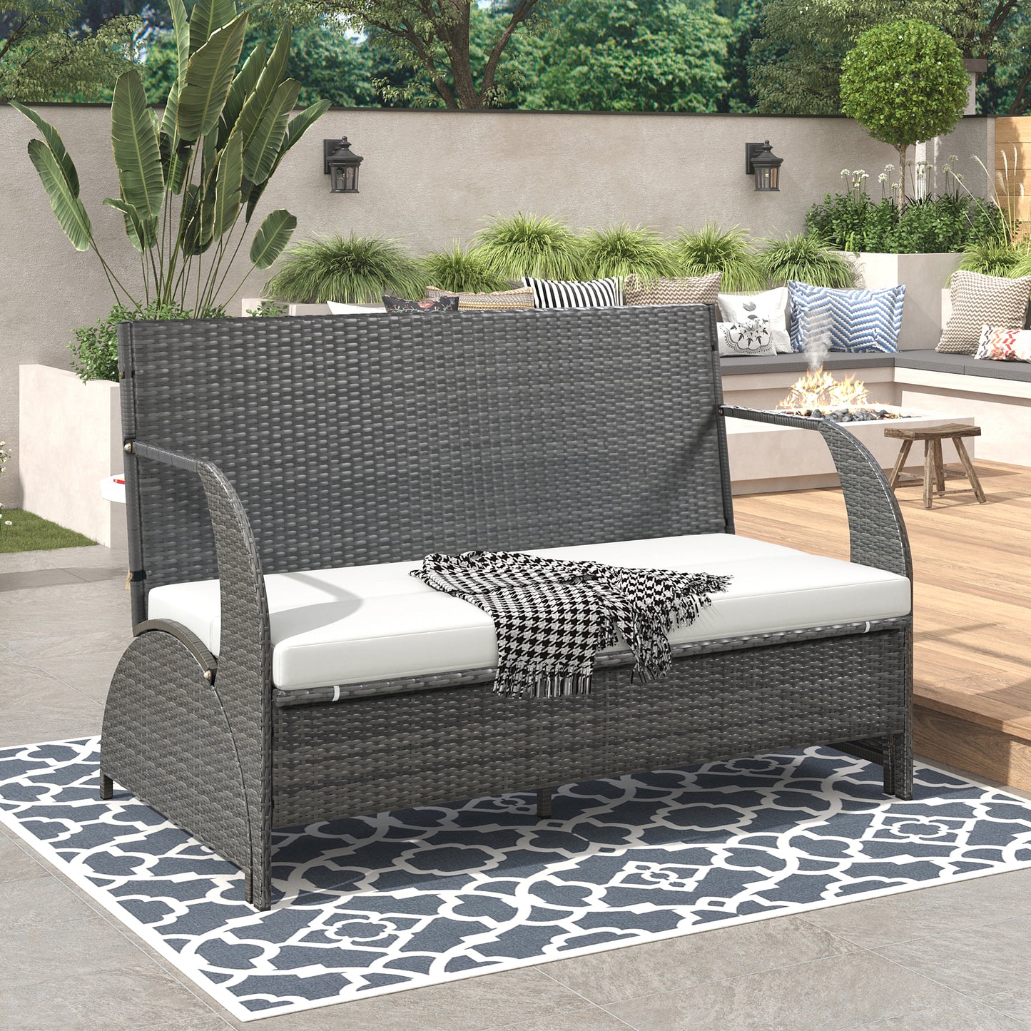 Dark grey wicker loveseat with white cushions and houndstooth throw