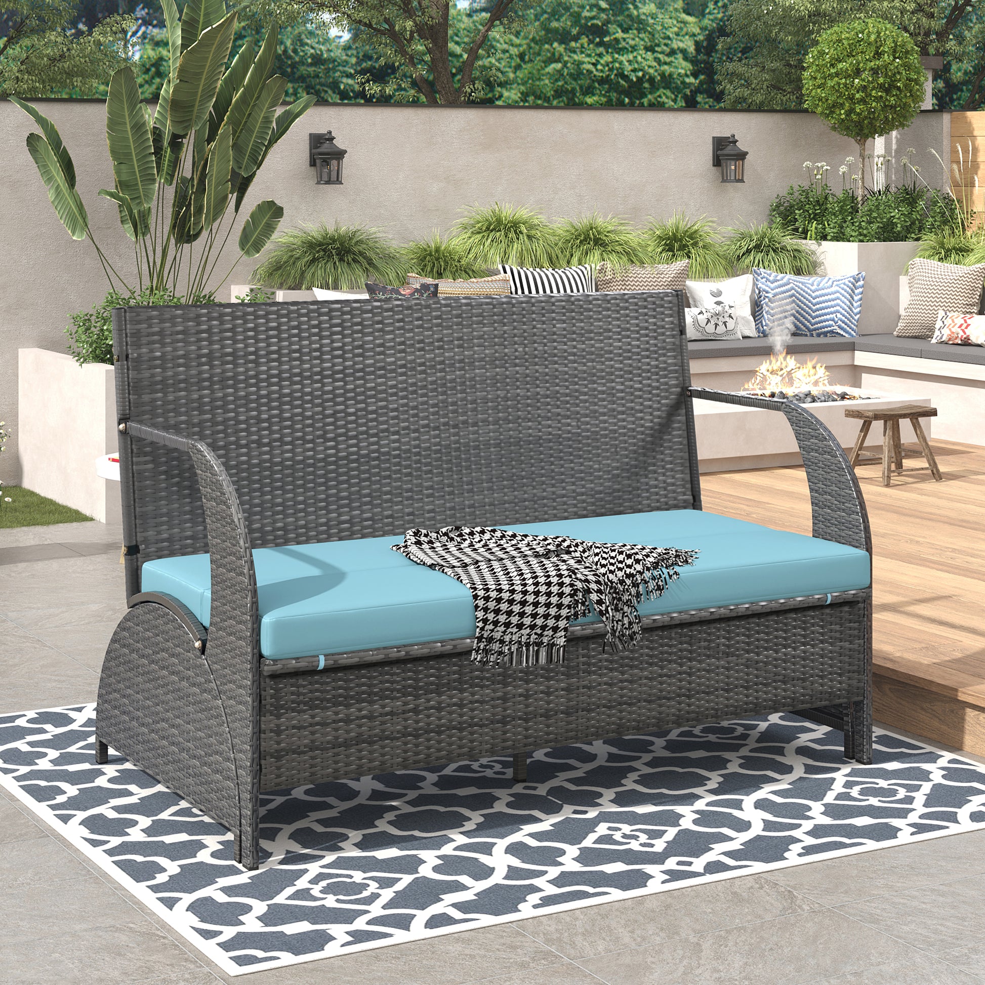 Dark gray wicker patio loveseat with a bright teal cushion and houndstooth throw
