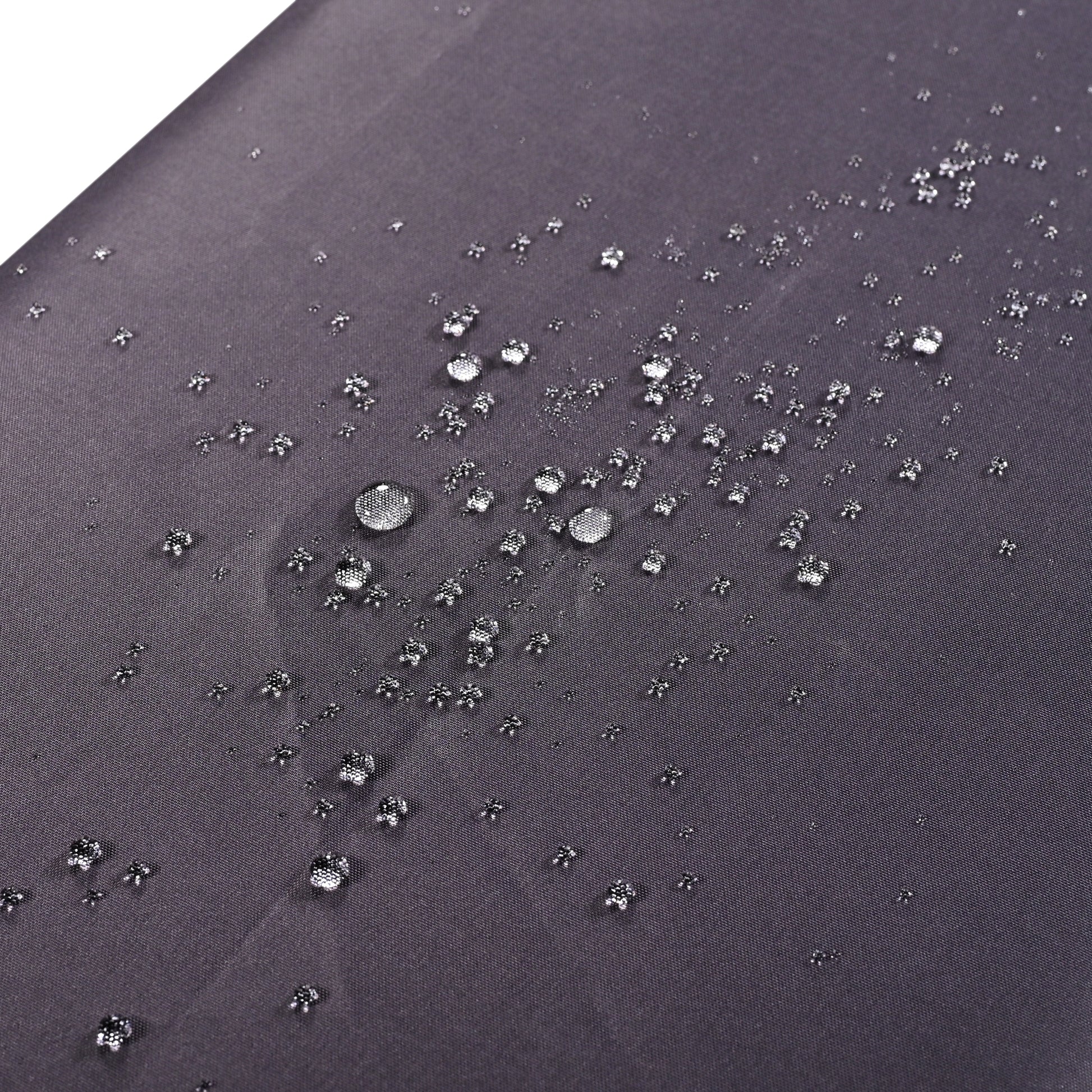 Dark grey fabric surface with small water beads demonstrating water repellency
