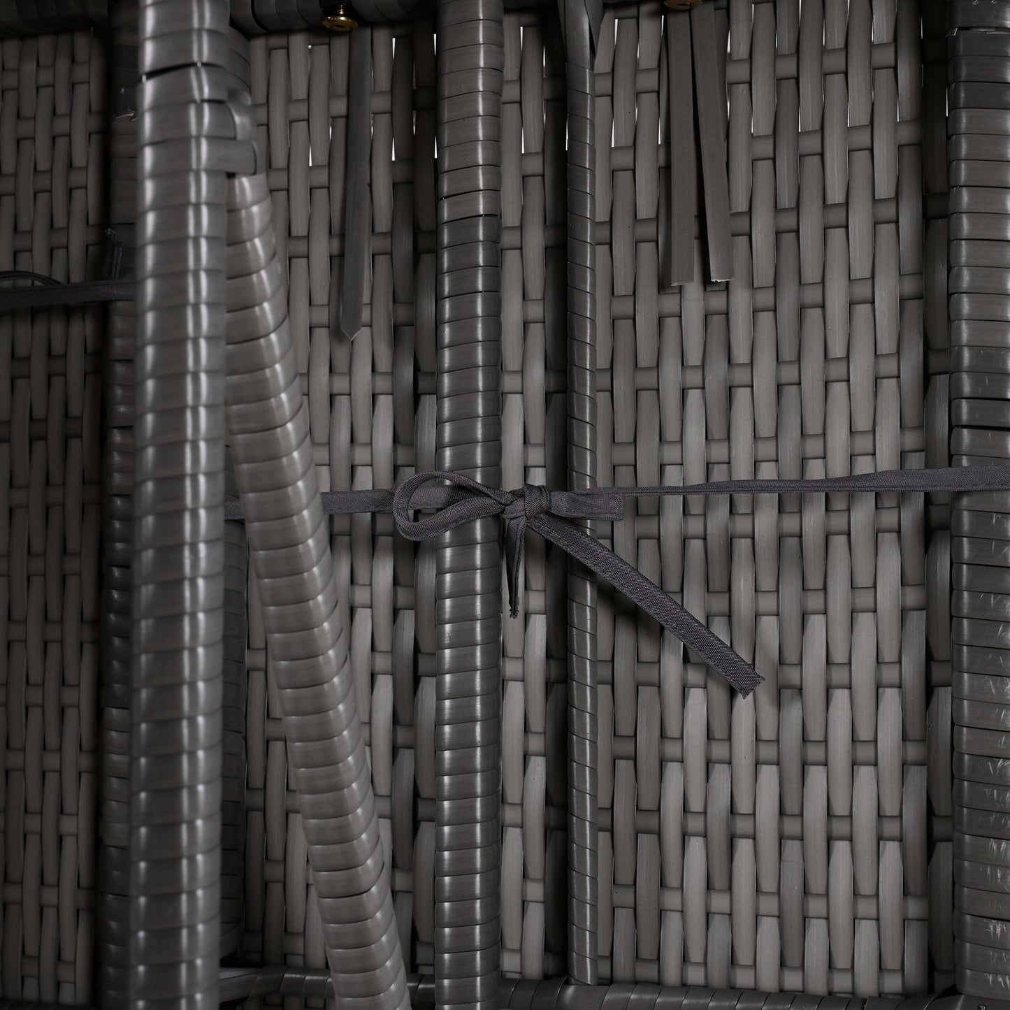 Closeup of a grey outdoor rattan chair weave with a dark grey tie detail