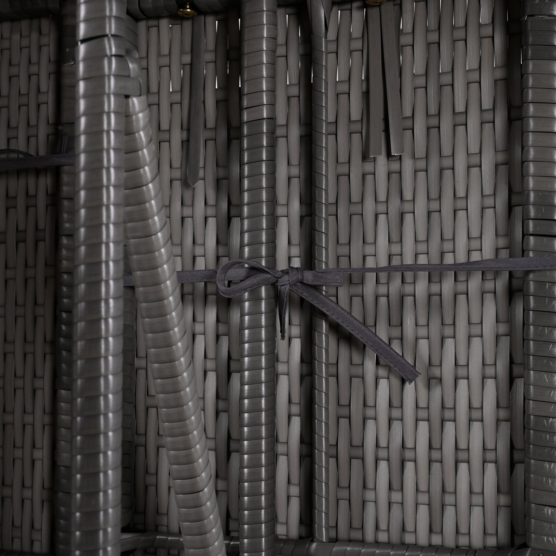 Closeup of a grey outdoor rattan chair weave with a dark grey tie detail