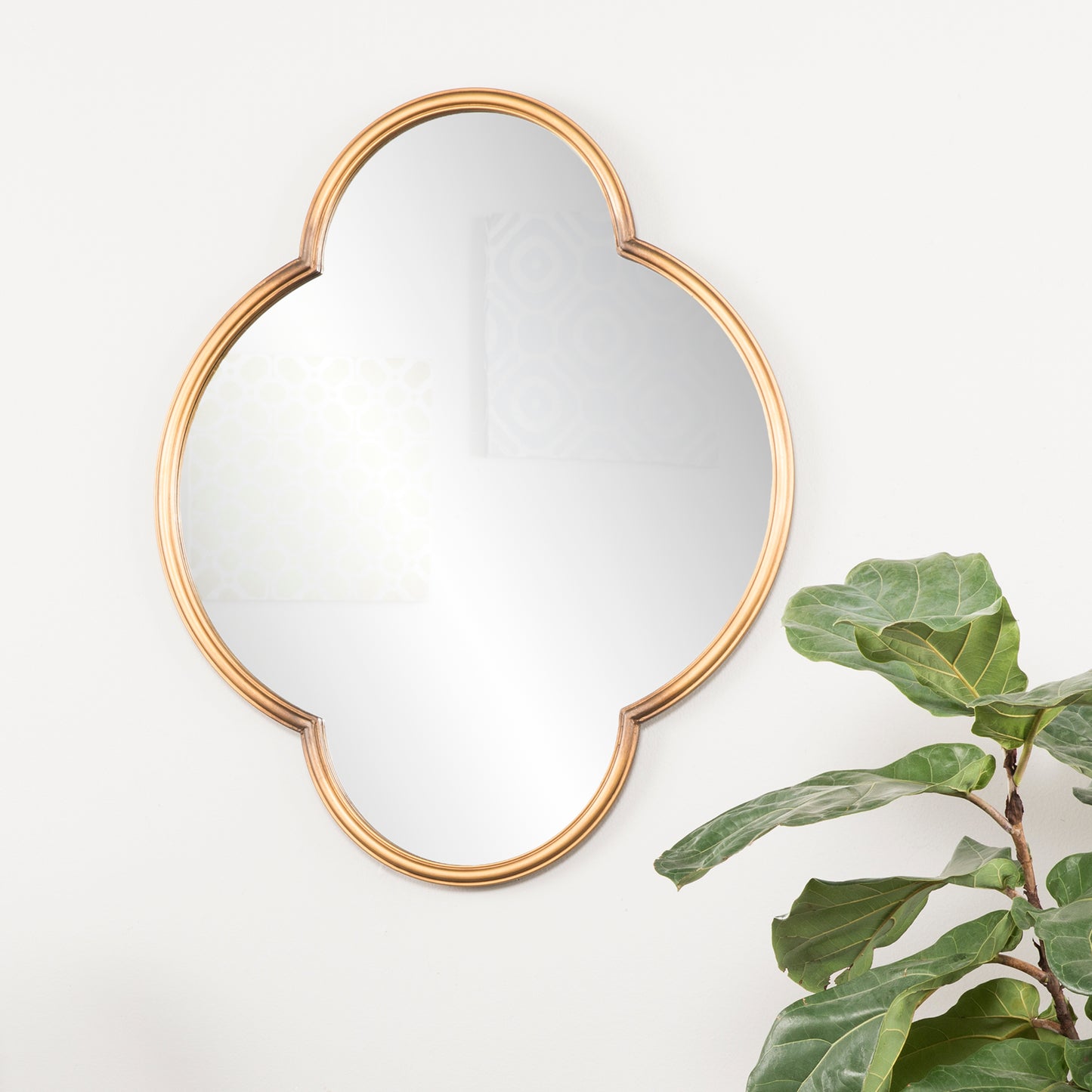 Gold quatrefoil mirror with reflective surface ideal for entryway decor