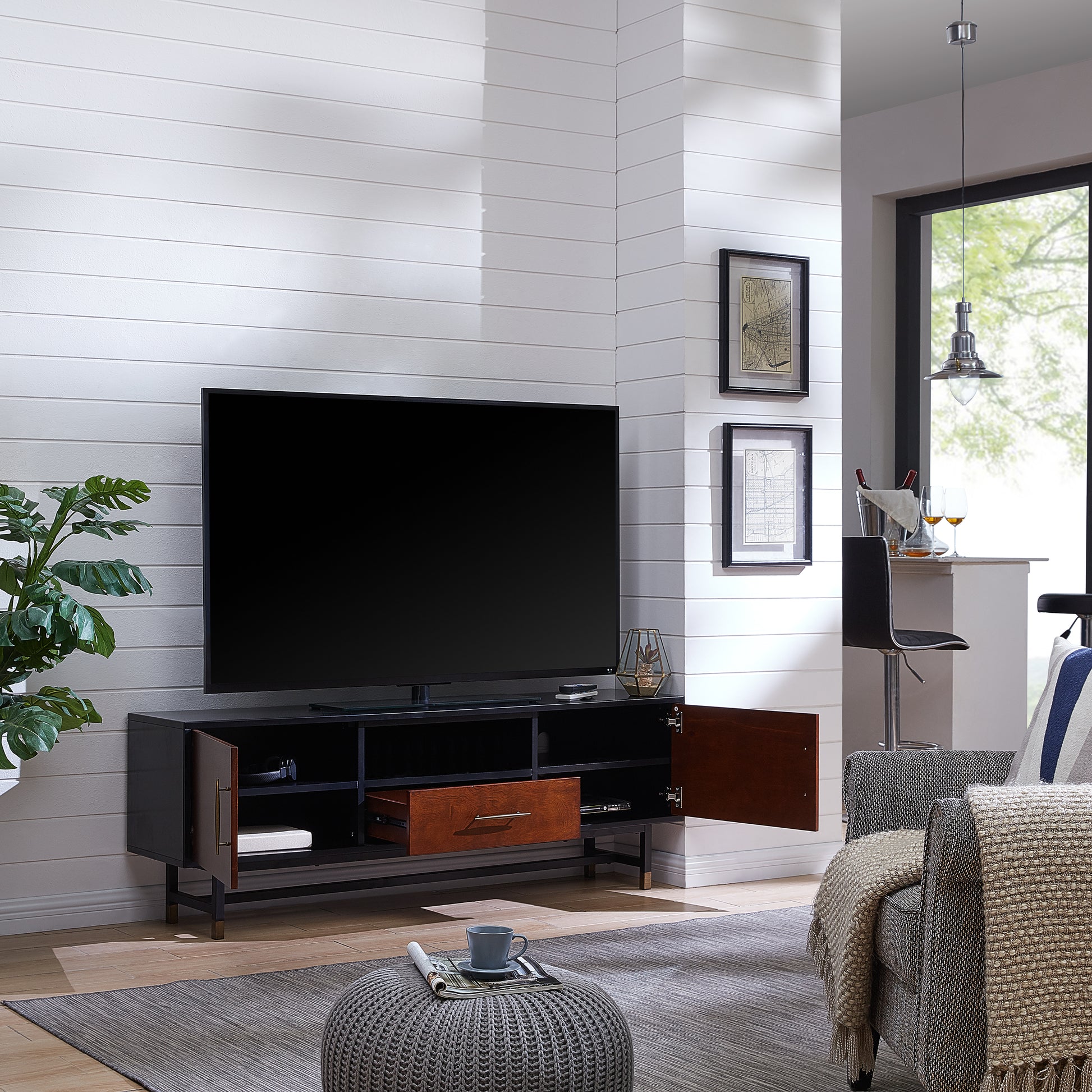 Black and wood media console with open compartments and a drawer showcasing modern living