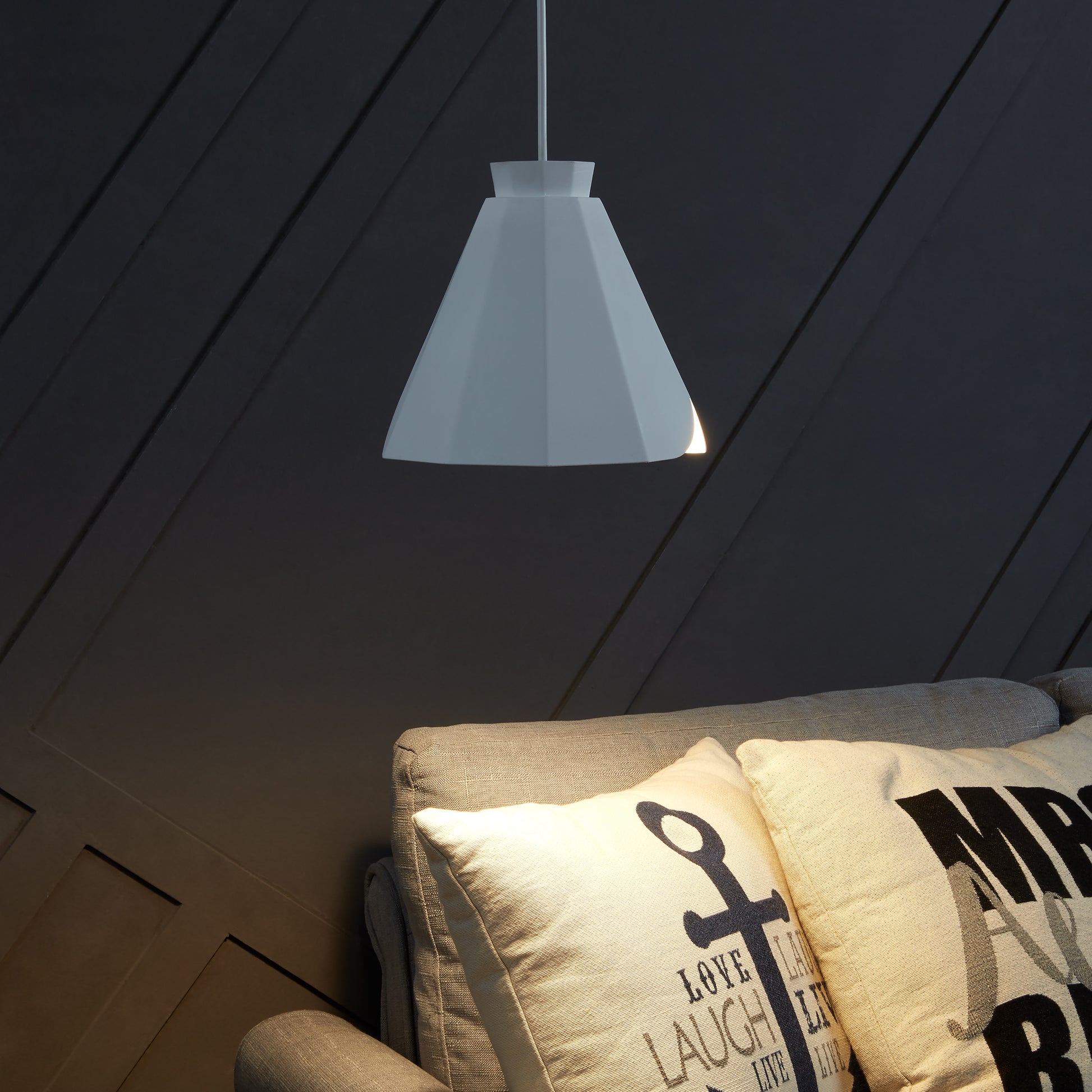White geometric pendant light illuminating a modern living space